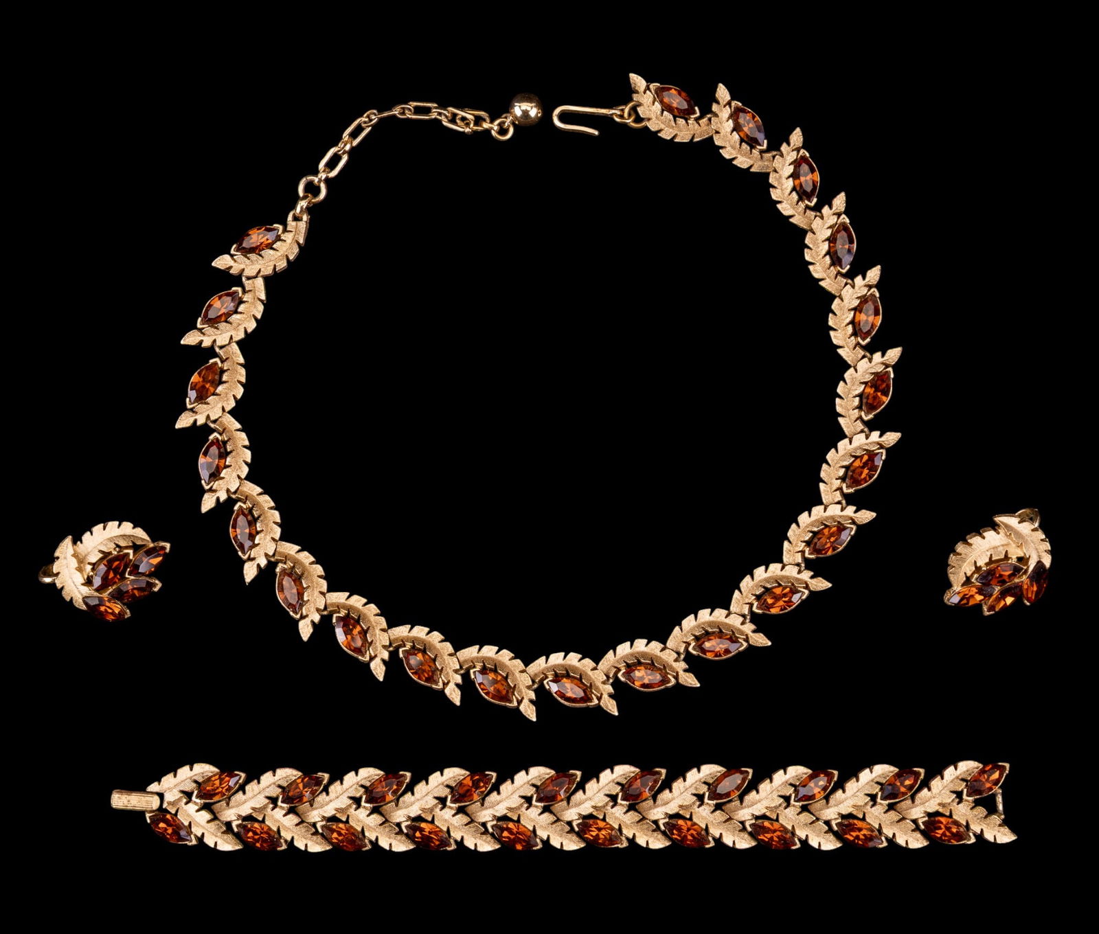 Trifari Gold-Tone Trio: Trifari gold-tone trio with amber-colored stones including a necklace, bracelet, and earrings set. Necklace drop measures approx. 7".