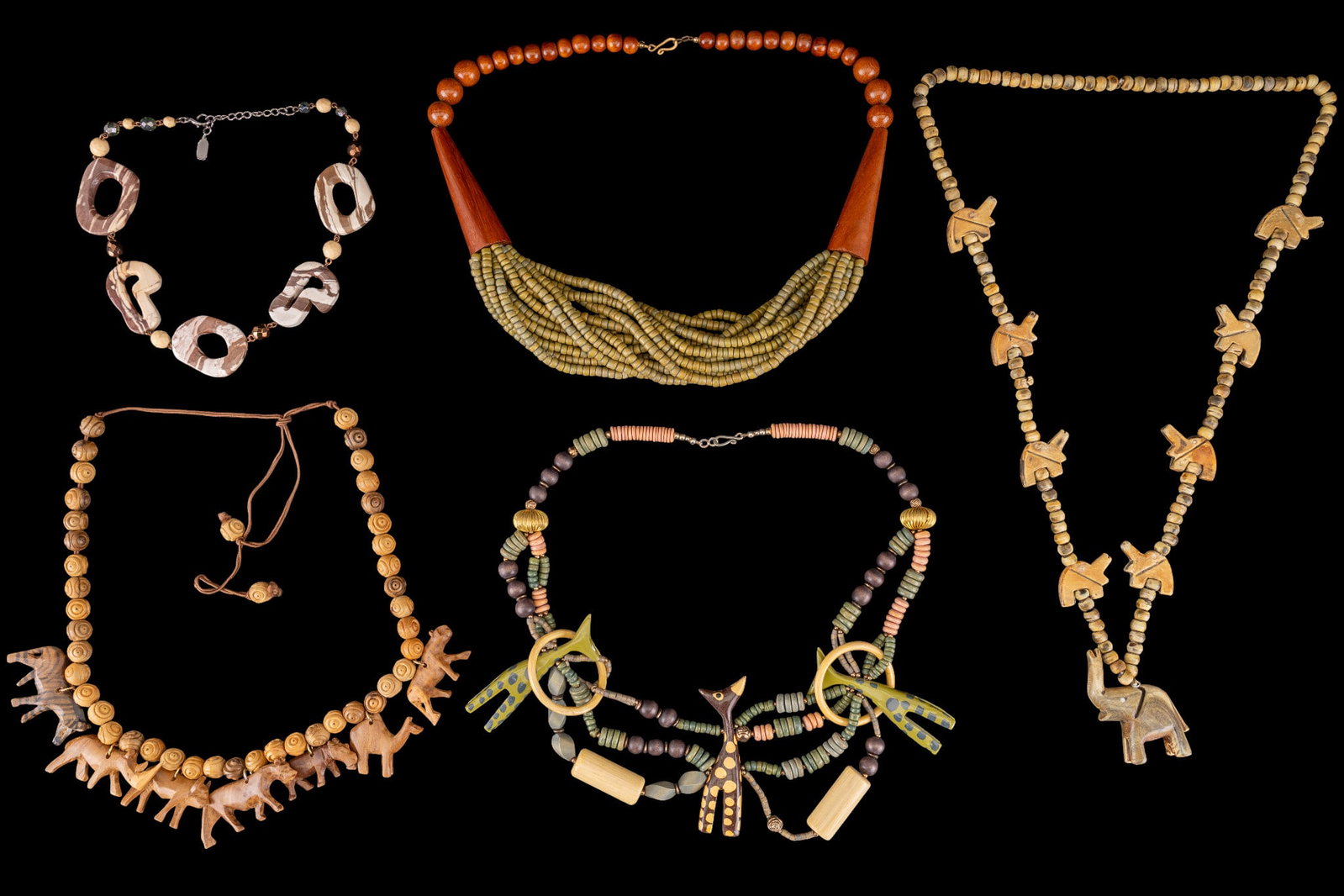 Carved Wood Animal Necklaces: Group of necklaces featuring carved wood animal and floral beads, smooth spherical wood beads, and polished stone beads.