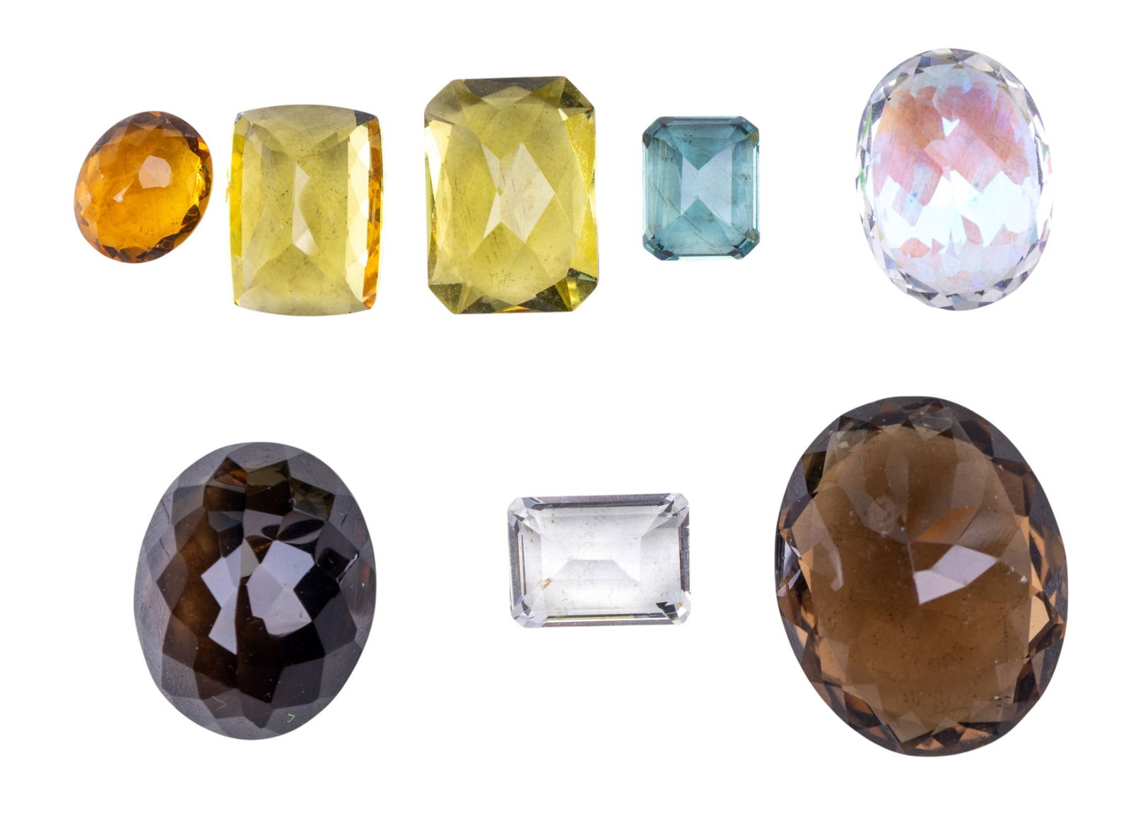 Semi Precious Cut Loose Stones: Collection of semi precious cut loose stones featuring oval cut smoky quartz (27mm and 23mm), iridescent spinel (20mm) and citrine (13mm), a brilliant cushion cut citrine (15mm), and three emerald cut