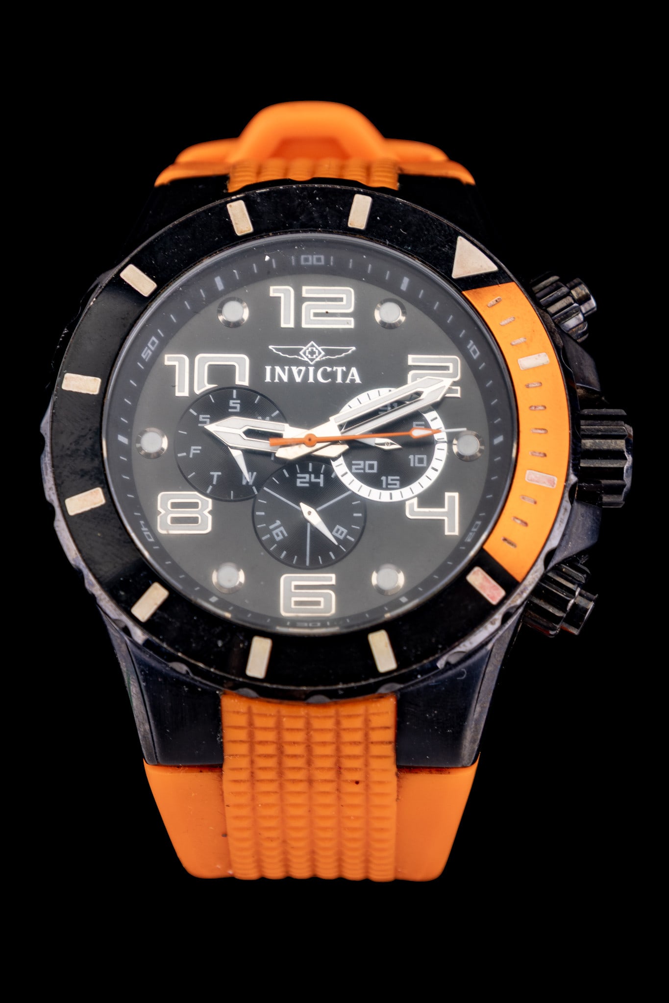 Invicta Watch: Large stainless steel Invicta Chronograph watch on orange rubber strap.