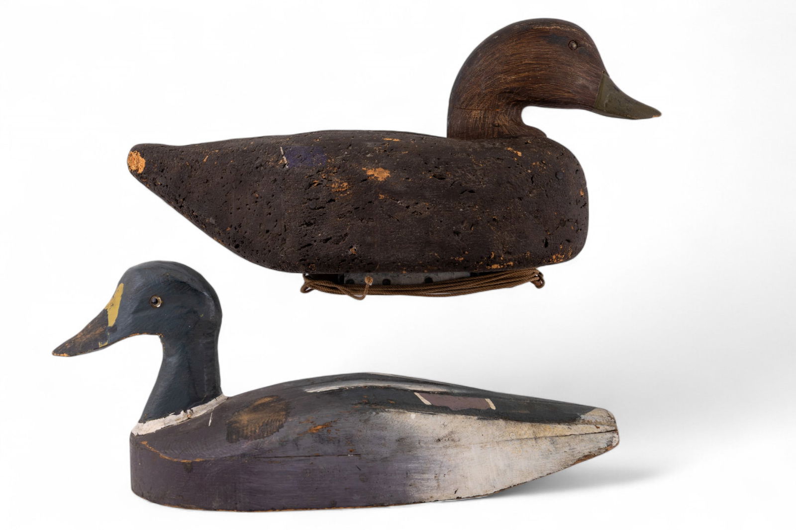 Wood and Cork Duck Decoys: A collection of vintage duck decoys featuring a carved wood and hand painted male mallard duck decoy, measures approx. 17" L, and an early cork body painted duck decoy with painted wooden head, measur