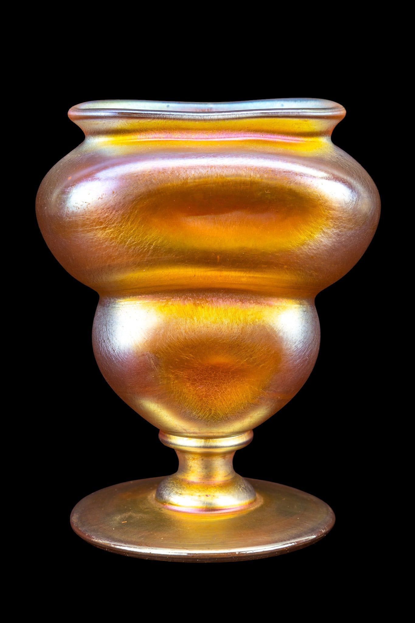 L.C. Tiffany Favrile Unusual Form Vase: Signed Louis Comfort Tiffany favrile art glass vase. Footed, ribbed, double waisted. Underside engraved "7681 N" along with signature in script L. C. Tiffany. Measures approx. 4" H.