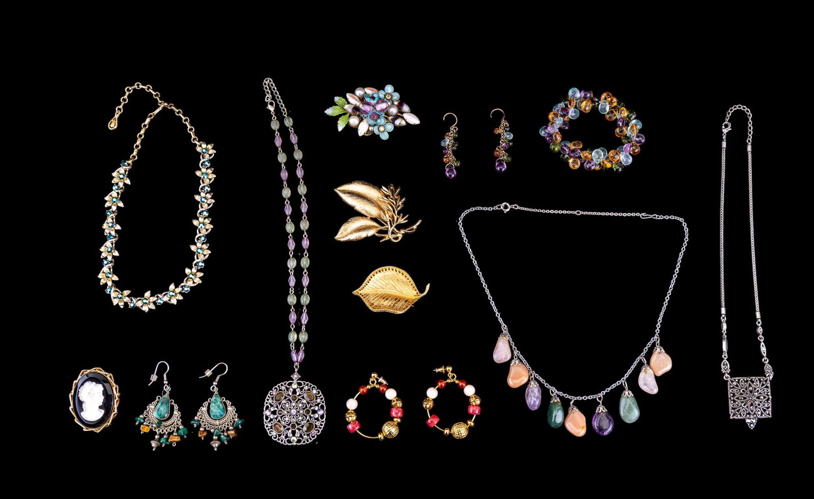 Designer Brooches, Necklace, and Other Jewelry: A collection of designer jewelry featuring a leaf and branch brooch by Sarah Coventry, a pierced leaf brooch by B.S.K., a blue rhinestone and gold tone floral necklace by Coro, malachite and tiger's e