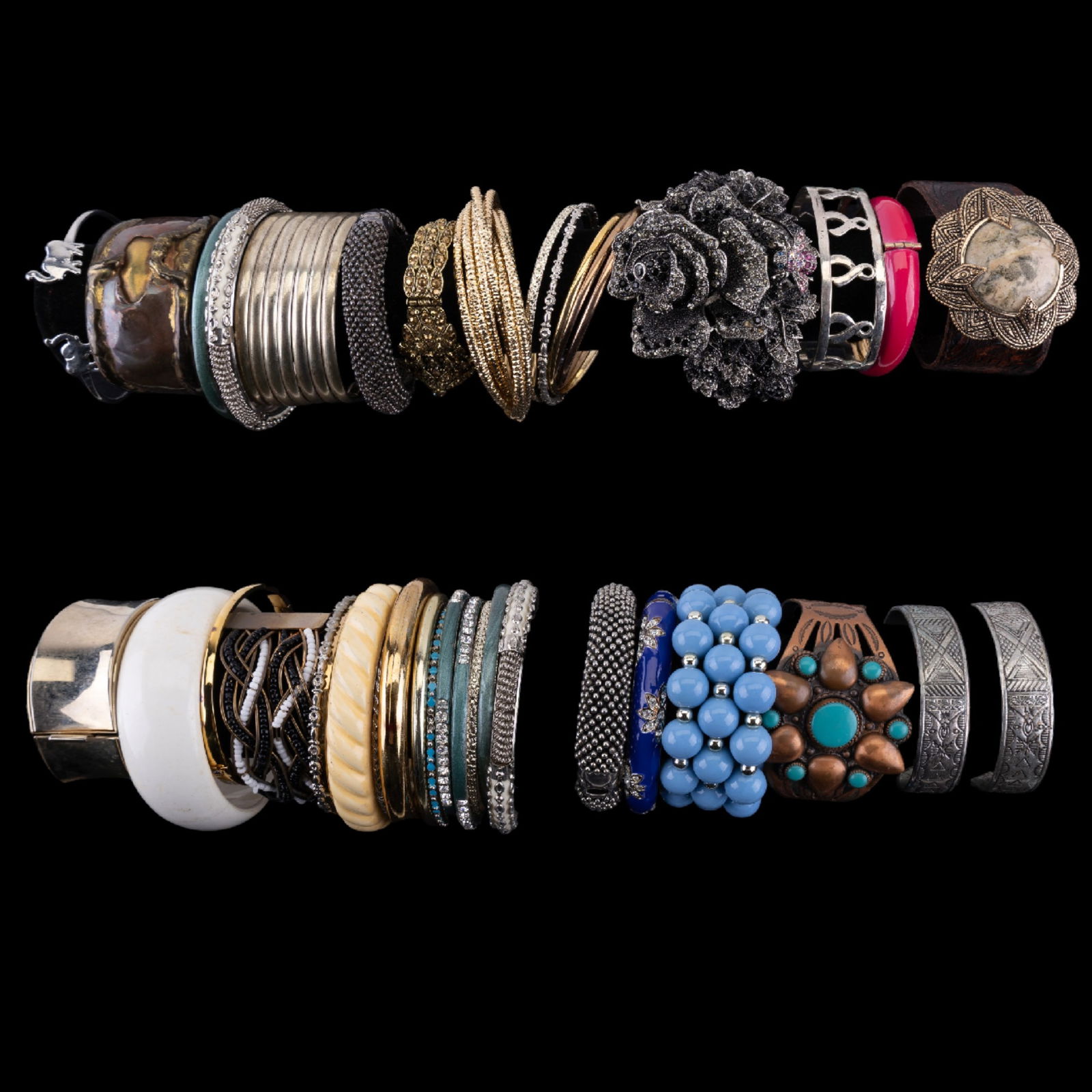 Vintage Cuff and Bangle Bracelets: A collection of vintage gold tone, silver tone, plastic, and rhinestone bangles and cuff bracelets featuring a Barse tooled leather cuff with bronze and African opal center, a Native American style co