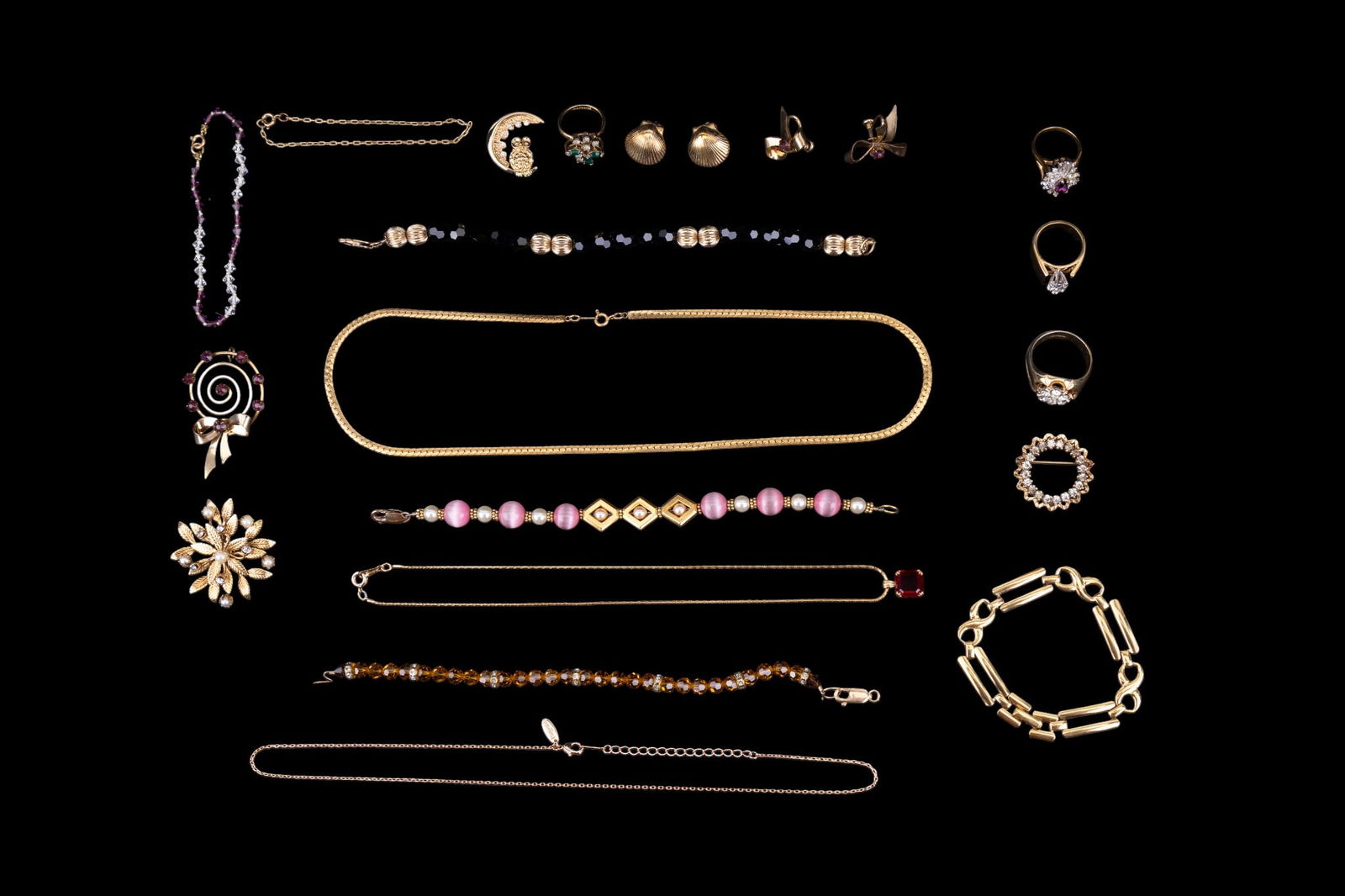 Vintage Gold Filled and Plated Jewelry: A collection of vintage gold filled and plated jewelry featuring brooch and screw back earring set with purple cut stones, facet cut crystal beaded bracelets with gold filled clasps, plated and filled