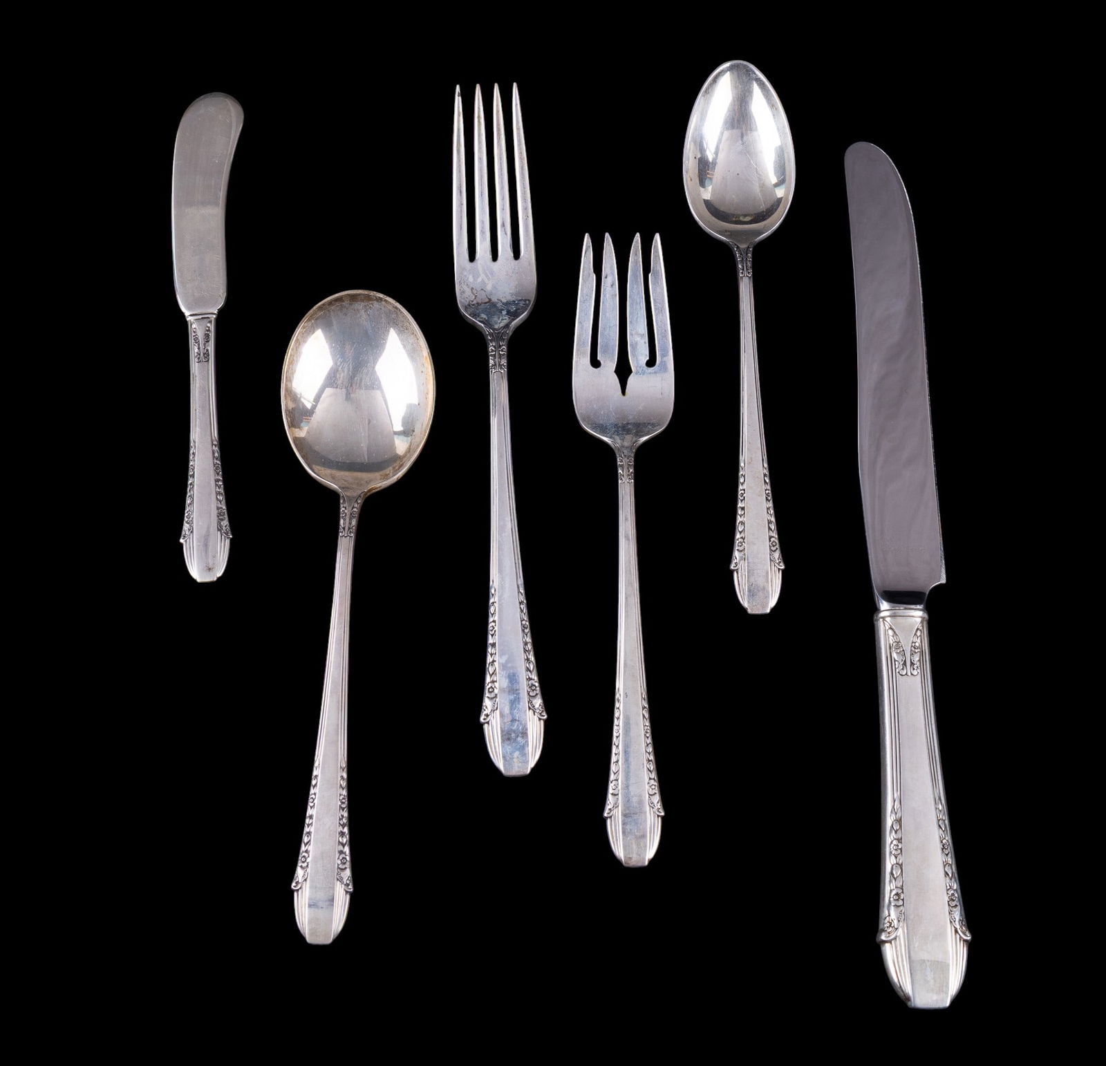 Intl. Sterling .925 "Enchantress" Place Setting: A place setting from International sterling made from .925 silver including a dinner fork, soup spoon, salad fork, butter knife, and a dinner spoon along with a sterling handled knife. All items are i