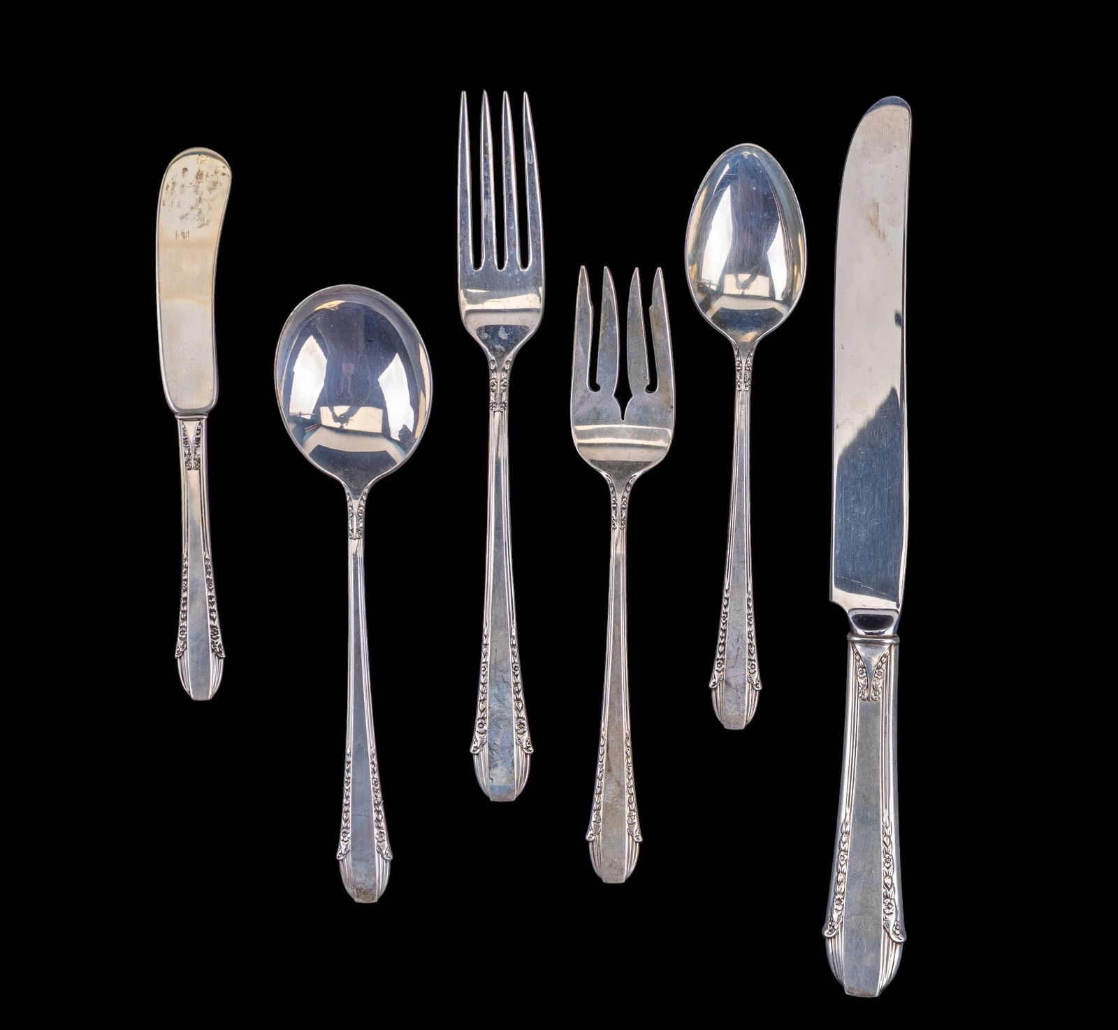 Intl. Sterling .925 "Enchantress" Place Setting: A place setting from International sterling made from .925 silver including a dinner fork, soup spoon, salad fork, butter knife, and a dinner spoon along with a sterling handled knife. All items are i