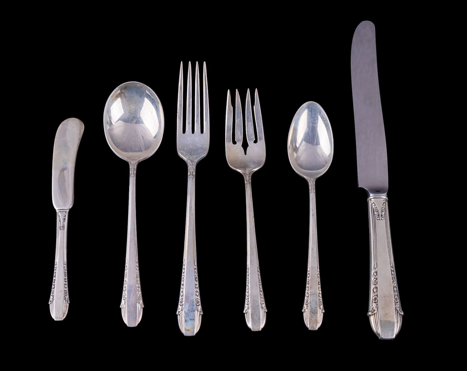 Intl. Sterling .925 "Enchantress" Place Setting: A place setting from International sterling made from .925 silver including a dinner fork, soup spoon, salad fork, butter knife, and a dinner spoon along with a sterling handled knife. All items are i