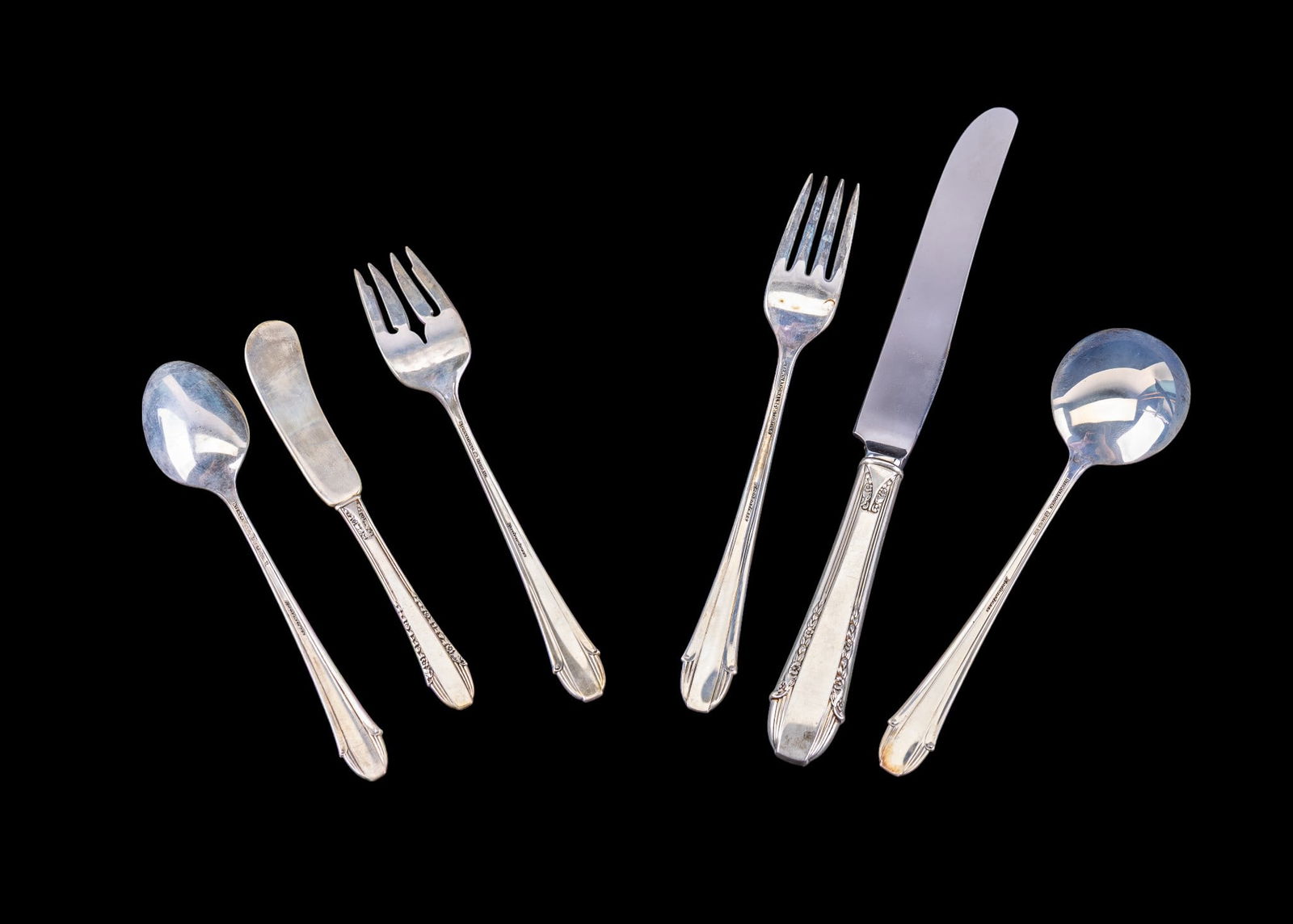 Intl. Sterling .925 "Enchantress" Place Setting: A place setting from International sterling made from .925 silver including a dinner fork, soup spoon, salad fork, butter knife, and a dinner spoon along with a sterling handled knife. All items are i