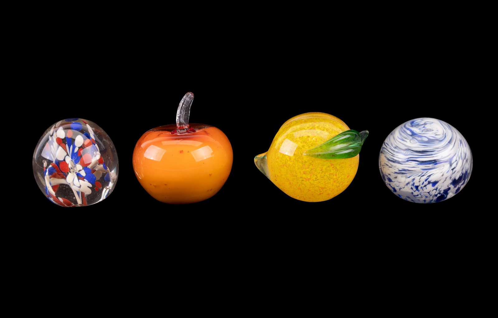 Art Glass Paperweights (4): 4 art glass objects, including 2 fruit-form examples (pumpkin shape / orange and lemon) with applied stems and 2 spherical paperweights featuring red, white, and blue millefiori-style inclusions and a