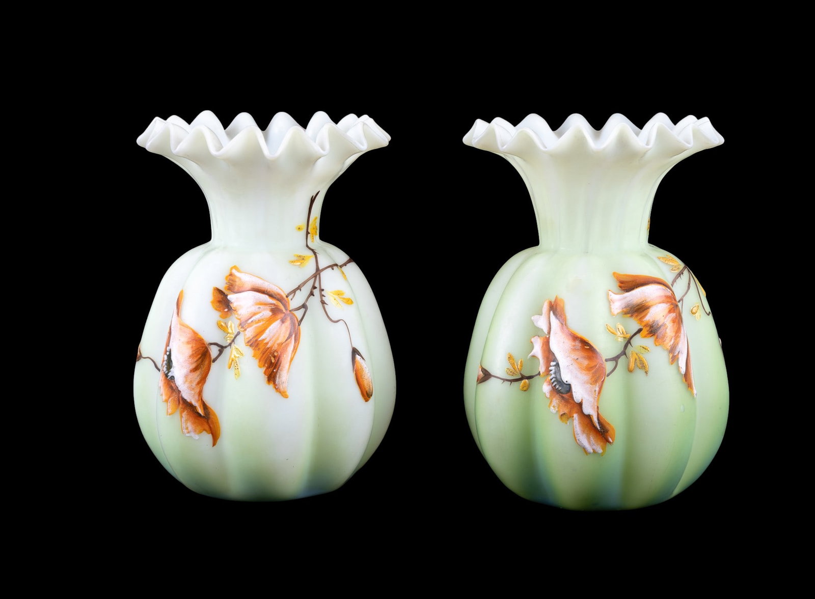 Fenton Burmese Satin Art Uranium Glass Vases (2): A pair of matching Fenton handpainted Burmese satin glass style uranium glass vases with ribbon tops and earth-toned tree decoration painted on outside. Vases measure approx. 6" high x 4.25" diameter.