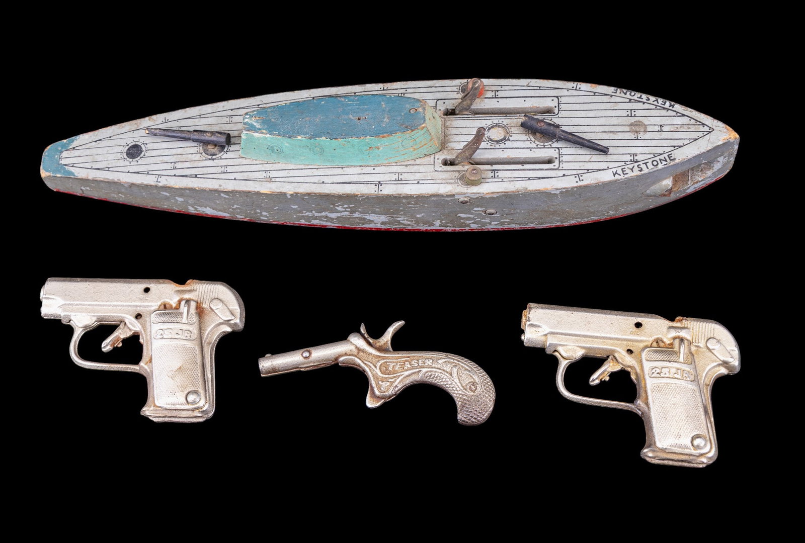 Early Vintage Cap Guns (3), Keystone Toy Ship: Three early vintage cap guns in as is condition. Triggers still pull, hammers functional, some rust. Also includes the USS Keystone toy wooden ship measuring approx. 14" long with spring loaded torped