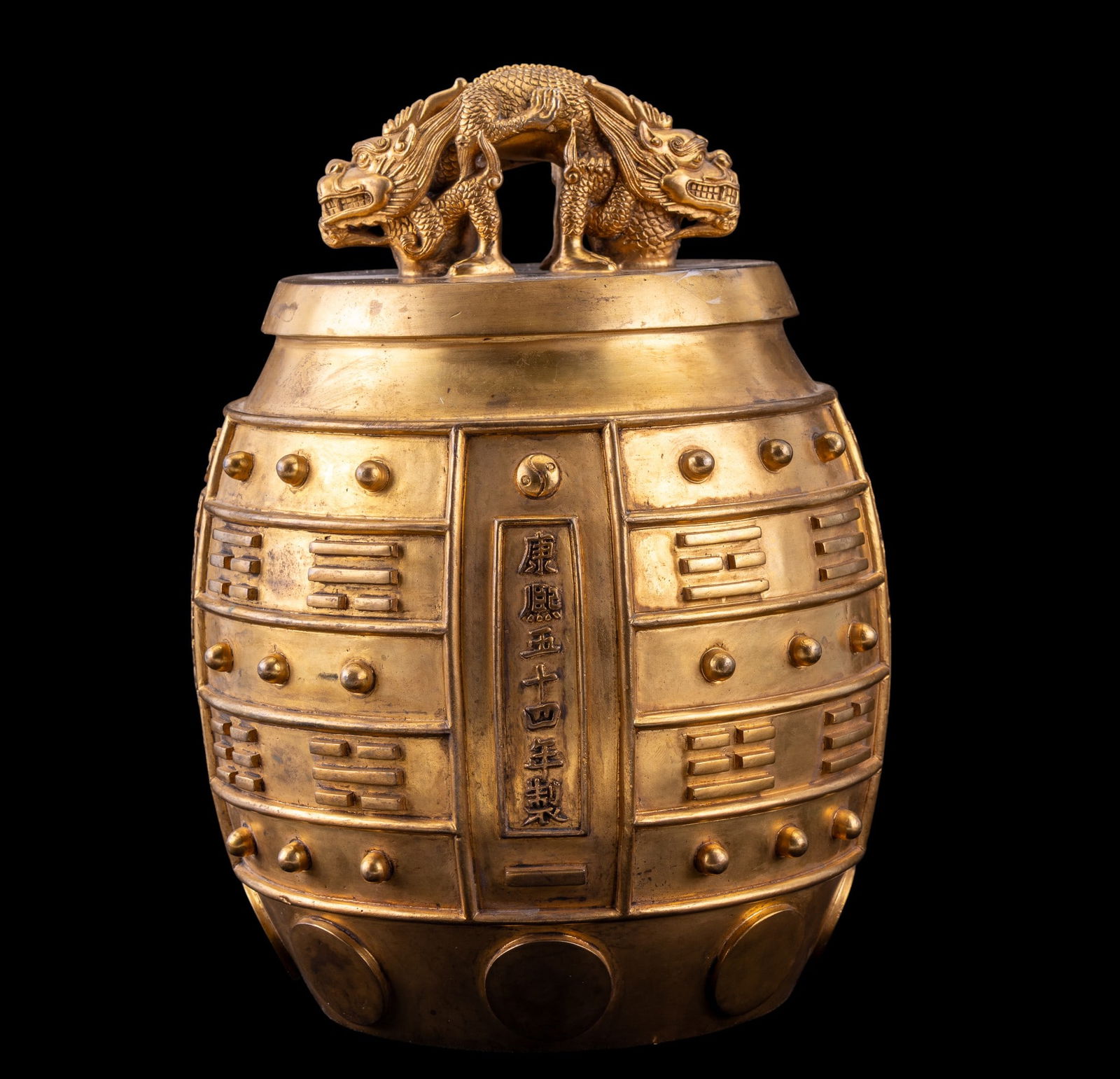 Chinese Gilt Bronze Ritual Bell: Chinese gilt-bronze ritual bell (bianzhong), surmounted by a sculptural 2-headed dragon finial. Body is cast with horizontal registers of raised bosses and relief panels. Measures approx. 12" H x 8" d