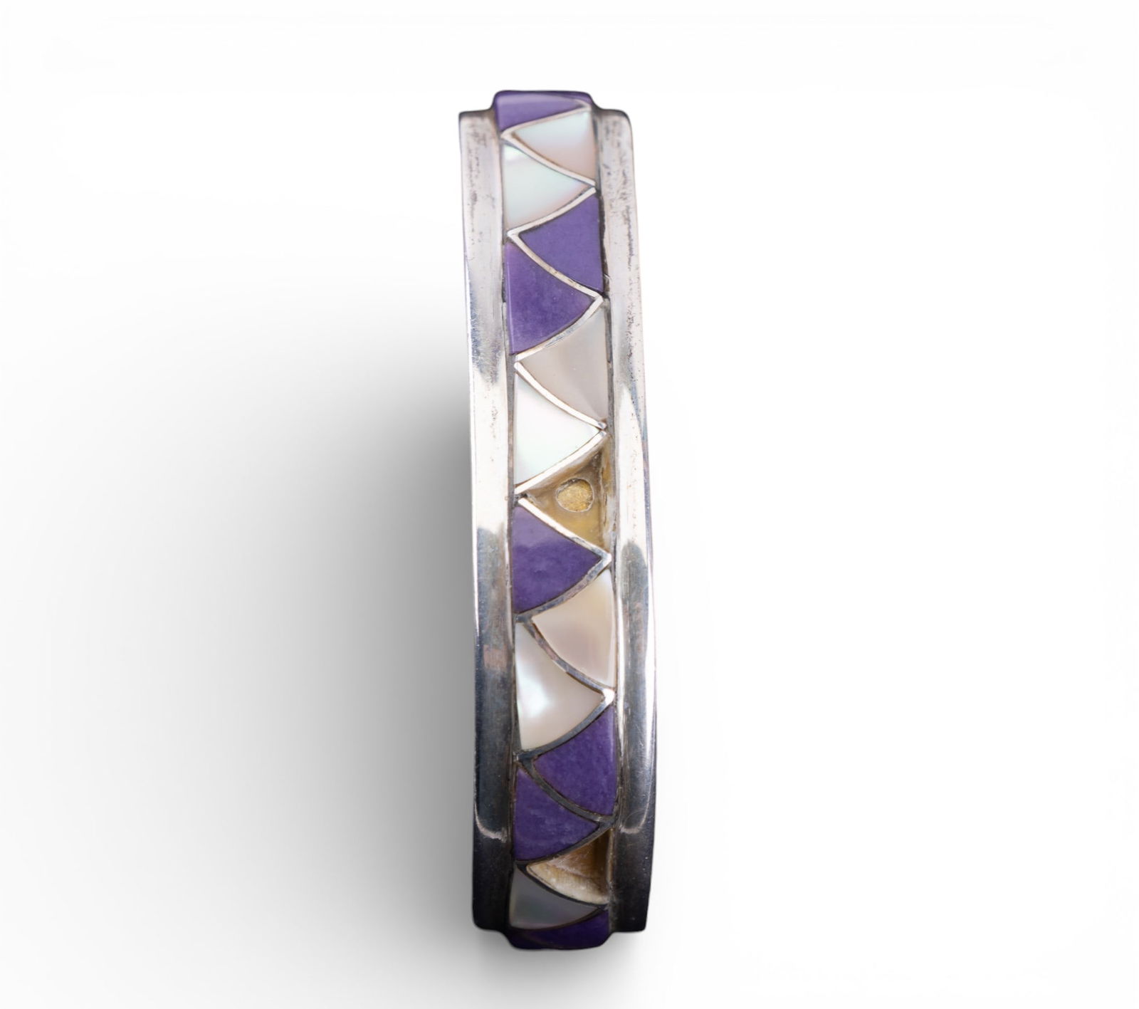 Orlinda Natiwa Sterling Bracelet: Sterling silver vintage Native American bracelet "signed Orlinda Natiwa", inlaid with mother of pearl and a purple stone Note 2 small pieces of inlay missing. 28g total.