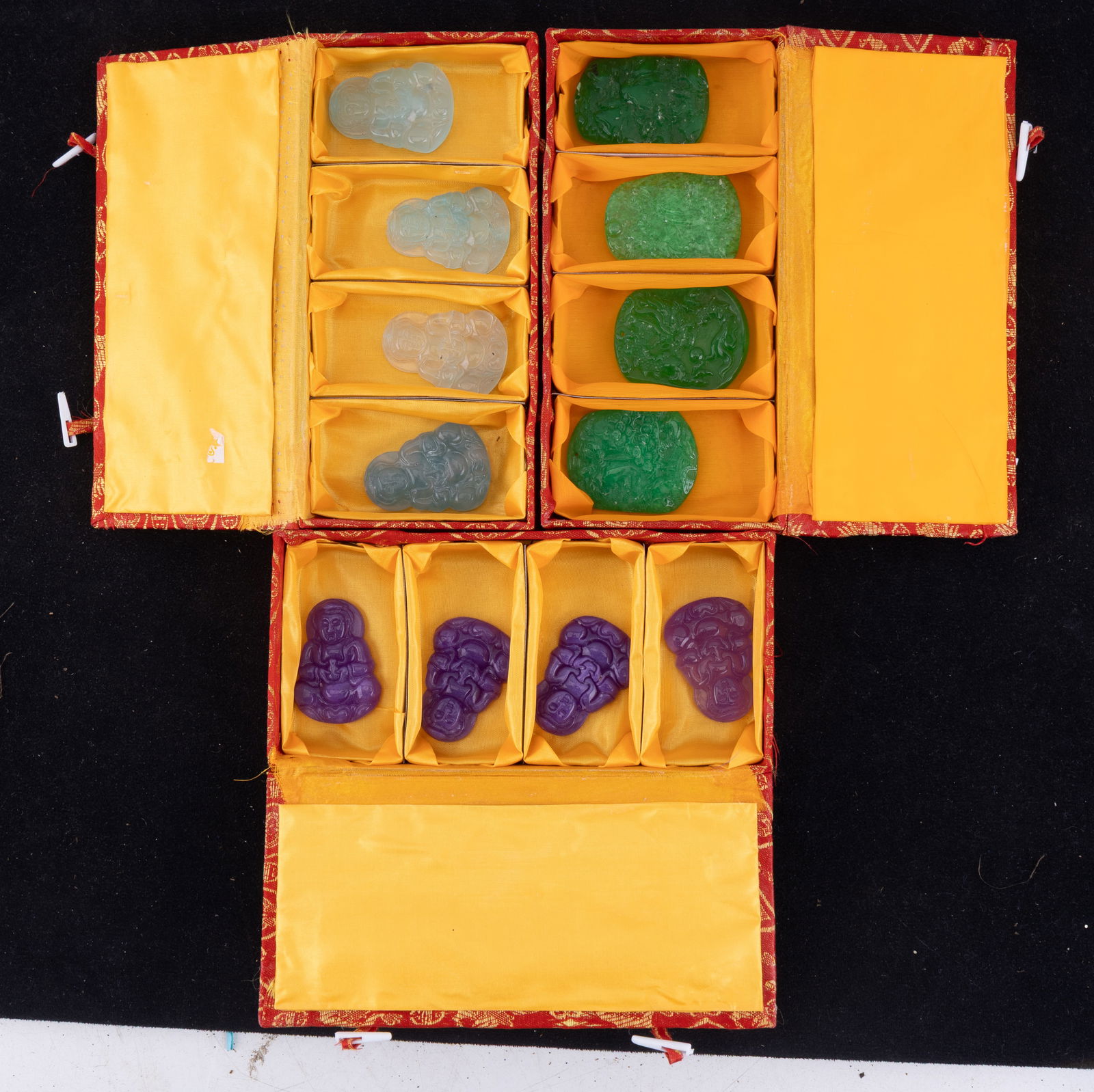 Jade Medallion Sets: Three sets of four jade medallions with boxes including four pale blue jade medallions depicting Buddha, four purple jade medallions depicting Buddha, and four apple green jade medallions, three of wh