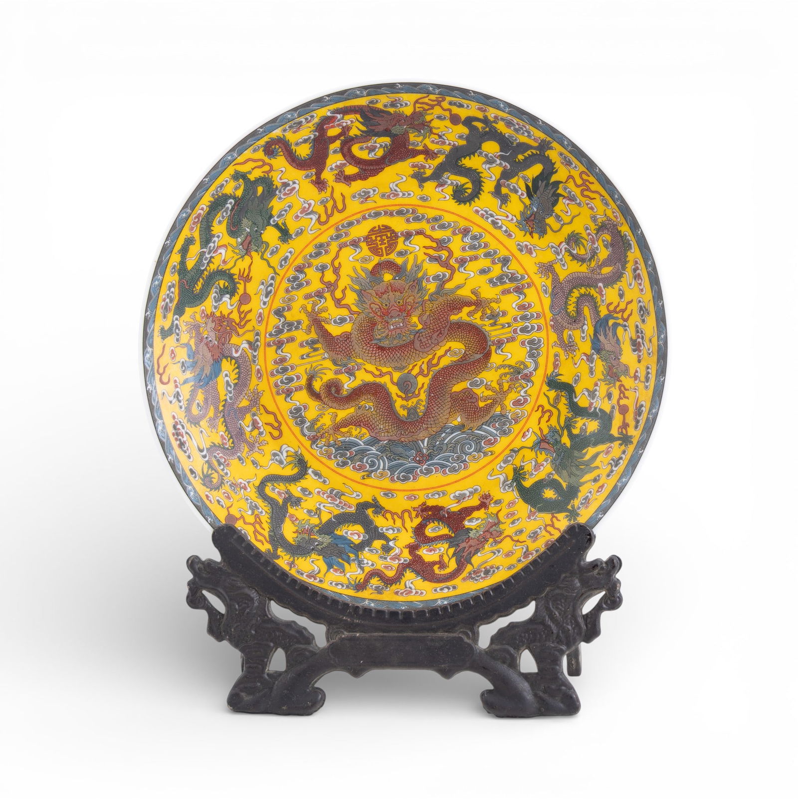 Chinese Qianlong 9-Dragon Famille Rose Plate: A Chinese Famille Rose porcelain 9-dragon plate with yellow ground, featuring the Qianlong period mark of the Qing Dynasty, with a faux wood folding plate stand. Measures approx. 10.5" diam.