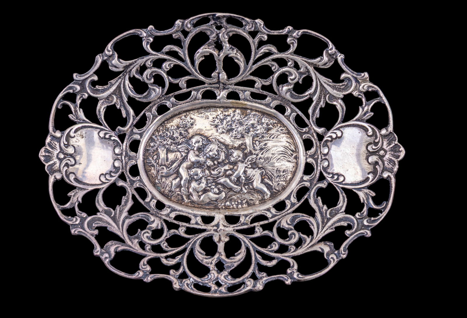 Continental European 800 Silver Pierced Dish: A Continental European 800 silver dish / tray from a provincial workshop, dated to the late 19th or early 20th century measuring ~1" x 5" x 6.25". It is embossed and pierced, with a tapestry-style bor
