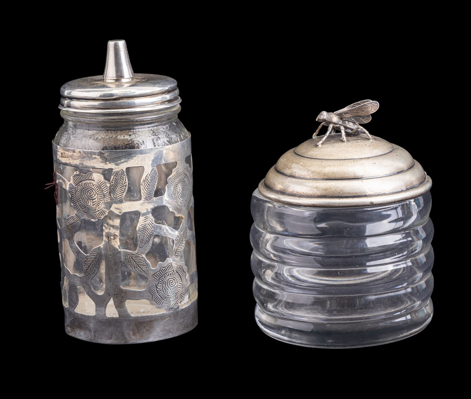 Sterling Silver Lidded Honey Jar, Mexican Silver: 2 Sterling mounted glass table items. First is a Mexican sterling silver and glass condiment dispenser with pierced foliate decoration, marked "925" and "Mexico", total sterling weight approx. 28.4 gr