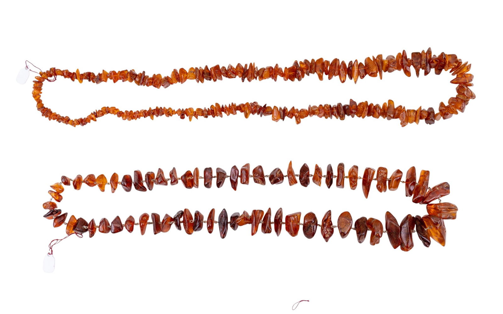 Graduated Natural Amber Necklaces: Two rough tumbled opera length graduated amber necklaces, measuring approx. 15" and 17" on the drop.