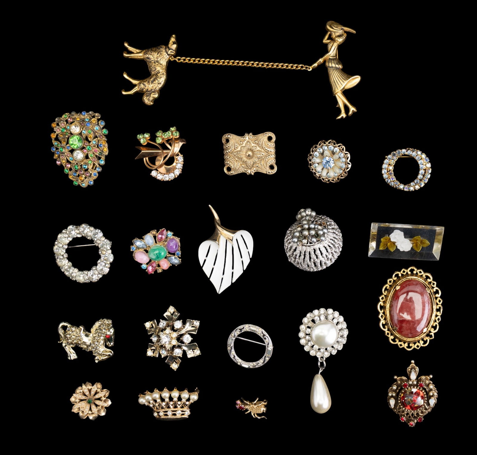 Coro and Other Vintage Brooches: A collection of vintage brooches featuring rhinestones and enamel motifs including a Coro dog walker two-part brooch, a Coro red and white glass filigree brooch, a stone cabochon brooch signed
