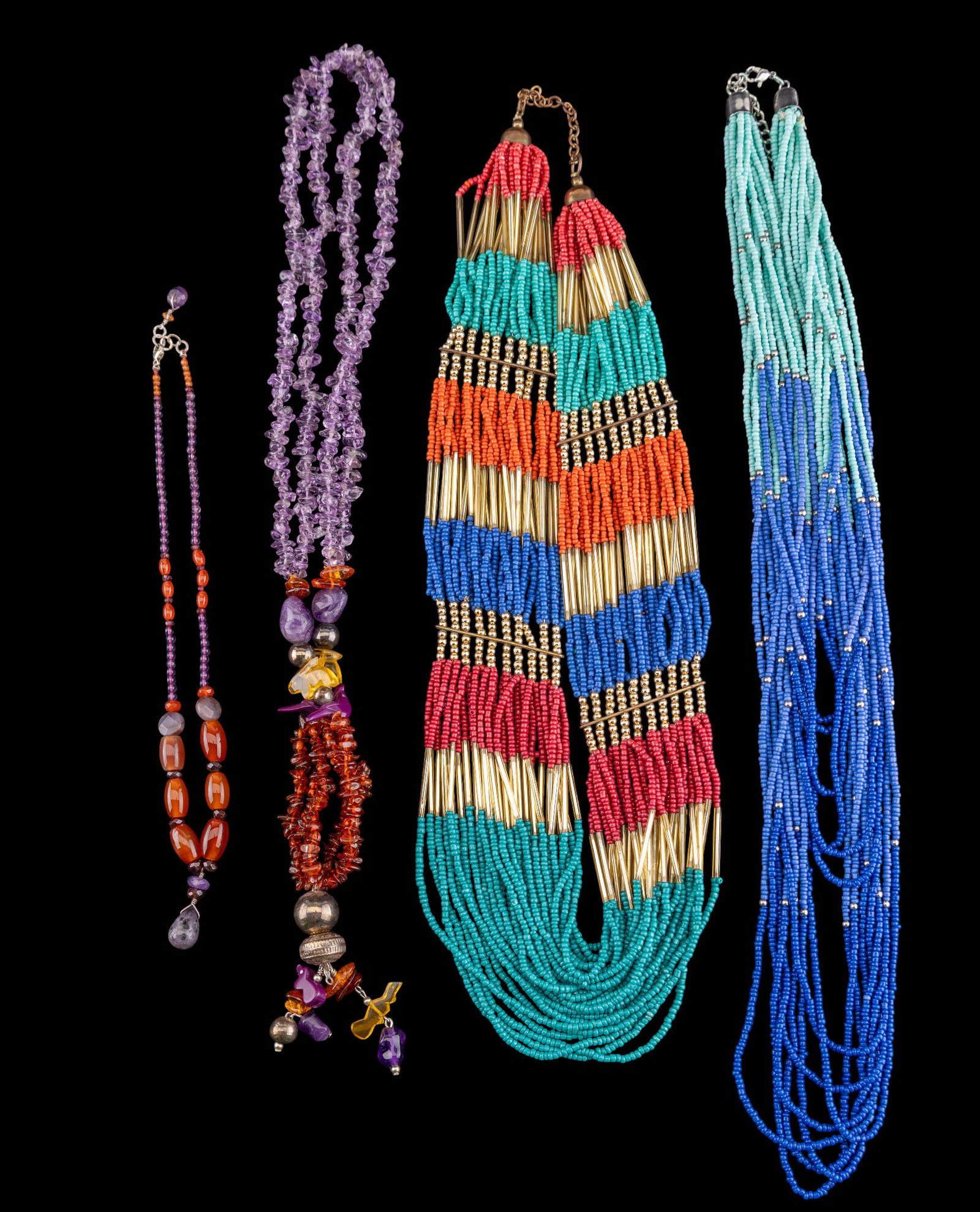 Amethyst, Amber, and Seed Bead Necklaces: Two multi strand, multi colored glass seed bead necklaces, an artisan fetish necklace featuring rough amber and amethyst stones and charms, and a hand crafted amethyst and carnelian necklace with ster
