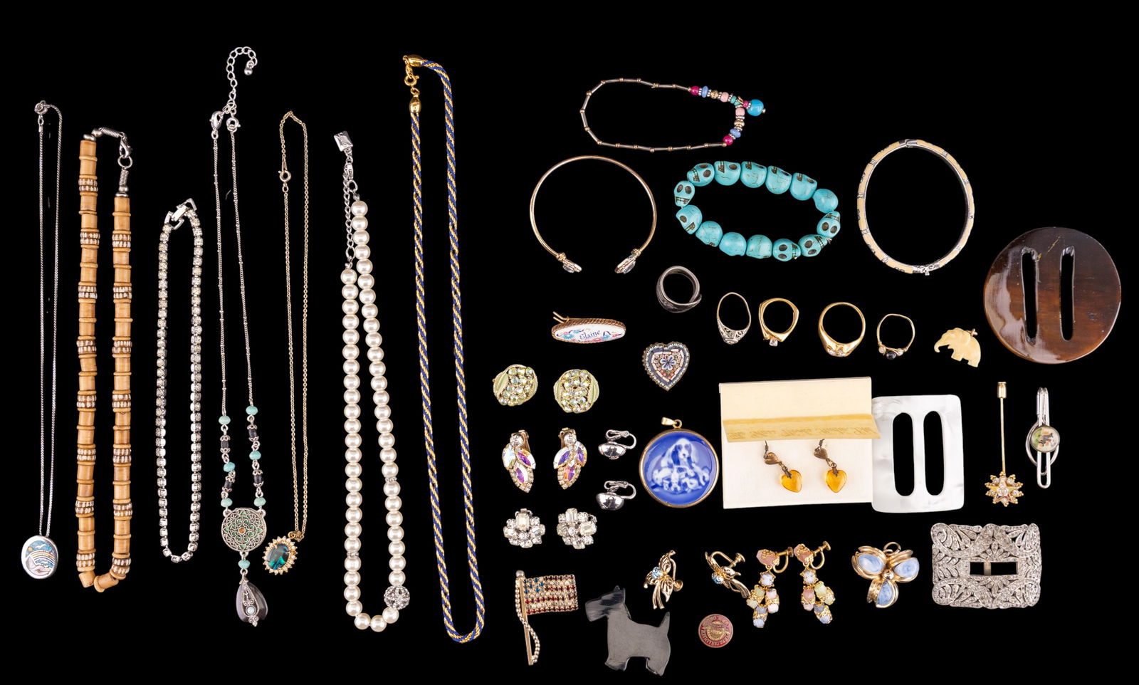 Vintage Estate Jewelry: A collection of vintage estate jewelry including a a gold tone rope and blue string twisted chain and silver tone half dome clip on earrings by Trifari, carved natural material elephant charm, renamel