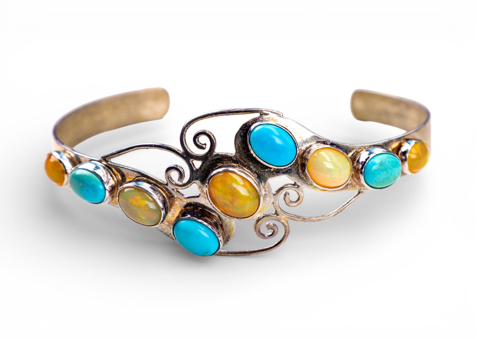 Turquoise and Opal Sterling Cuff Bracelet: A fine sterling silver cuff bracelet featuring filigree design motif and turquoise and opal cabochons, signed 'DTR' and marked 925. Total weight is approx. 18g.