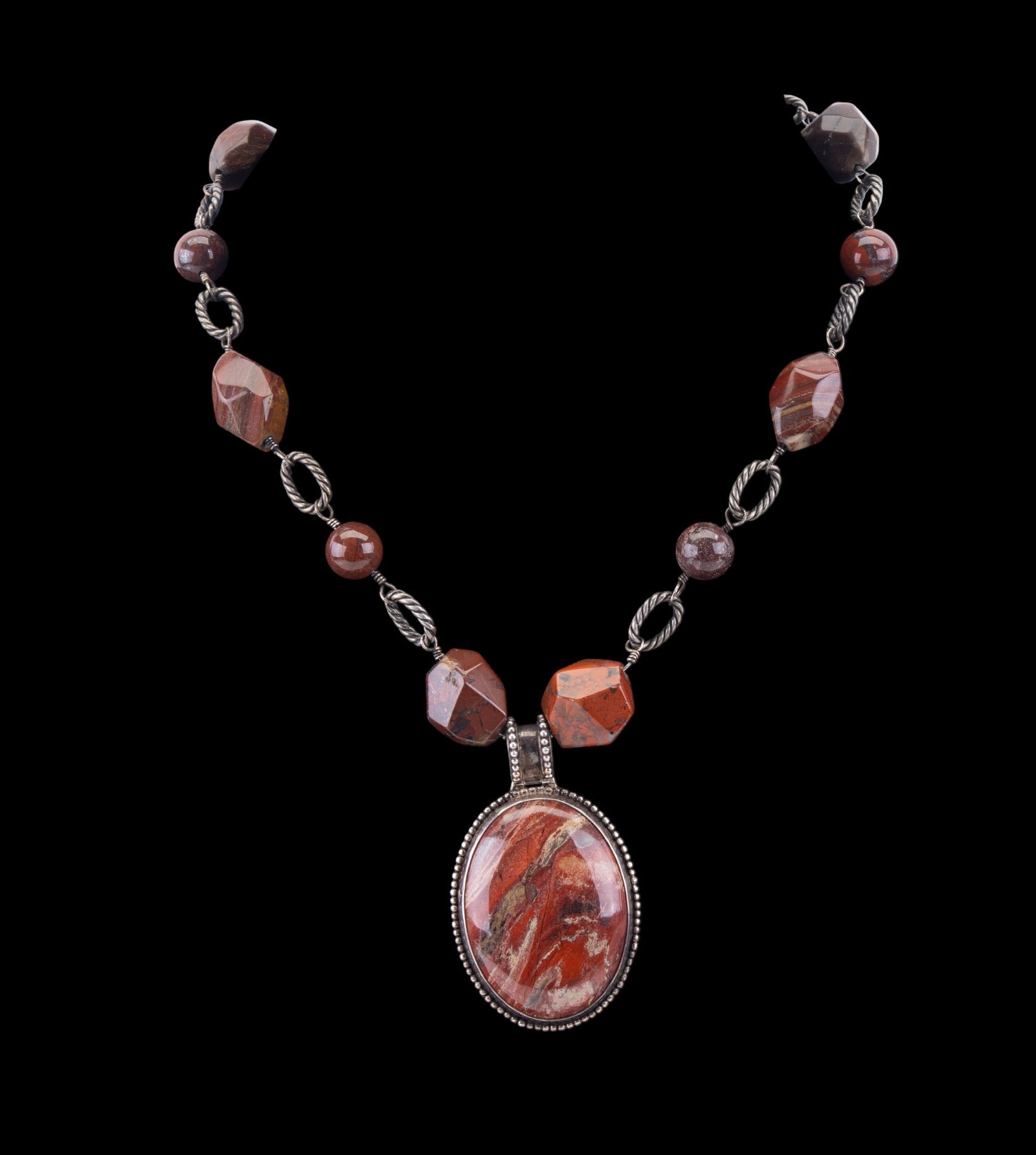 Sterling and Stone Necklaces: Two sterling silver and stone necklaces featuring a multi-strand glass seed bead and hematite necklace with sterling silver clasp, and a polished red jasper and sterling necklace featuring an oval red