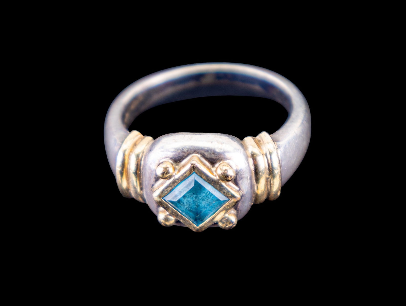 Sterling Silver and 14K Gold Ring: A sterling silver ring featuring a square cut blue topaz, approx. 5x5mm, and 14K gold accents, size 6.5, weighs approx. 7g total.