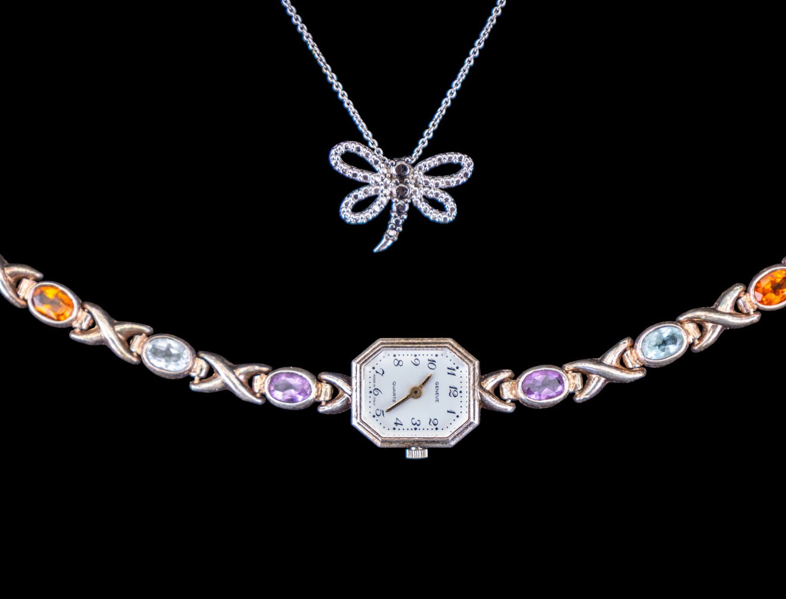 Sterling Silver Necklace and Wrist Watch: A sterling silver necklace featuring a sterling dragonfly pendant, chain measures approx. 9" on the drop, and a Geneve battery operated movement wrist watch in a sterling silver case featuring a sterl