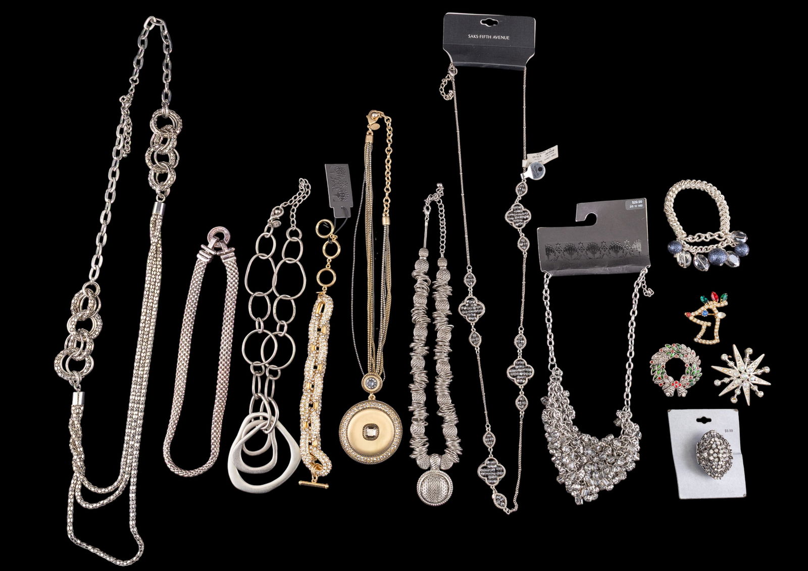 Designer / Fashion Costume Jewelry: Tray containing an assortment of costume jewelry, including chains, bracelets, brooches, and earrings. Items are silver tone with rhinestones and colorful accents. Made by Saks Fifth Avenue and others