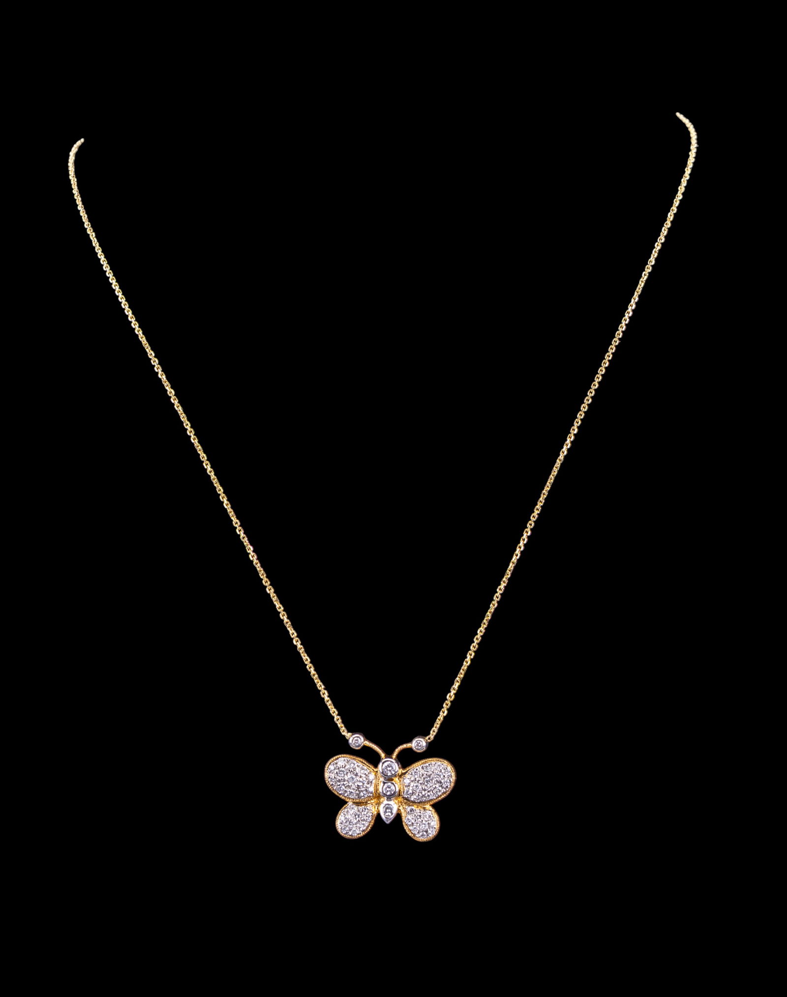 10K Yellow Gold Butterfly Pendant Necklace: 10K yellow gold necklace featuring a butterfly shaped pendant adorned with pav? set diamonds and larger central diamond accents. The necklace measures 18.5 inches in length and weighs 4.42 grams. The