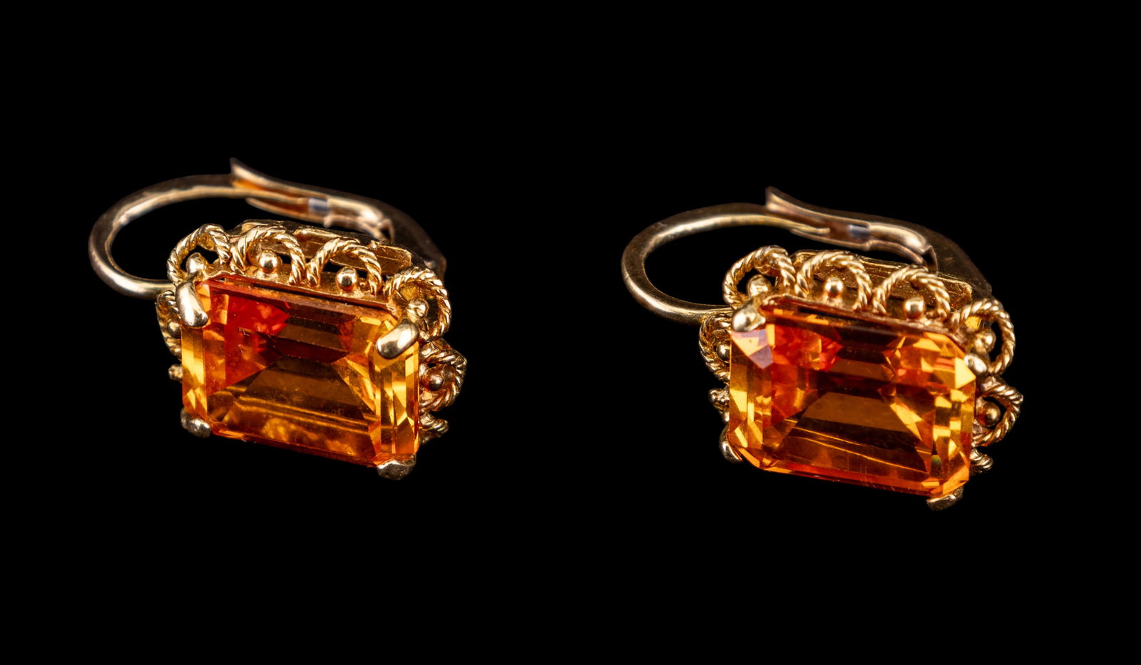 18K Gold Emerald-Cut Citrine Cocktail Earrings: Cocktail earrings featuring emerald cut citrine stones set in 18K yellow gold. Each citrine stone measures approximately 6/16 x 1/2 inch. Earrings weigh a combined 8.44 grams, with each weighing 4.22