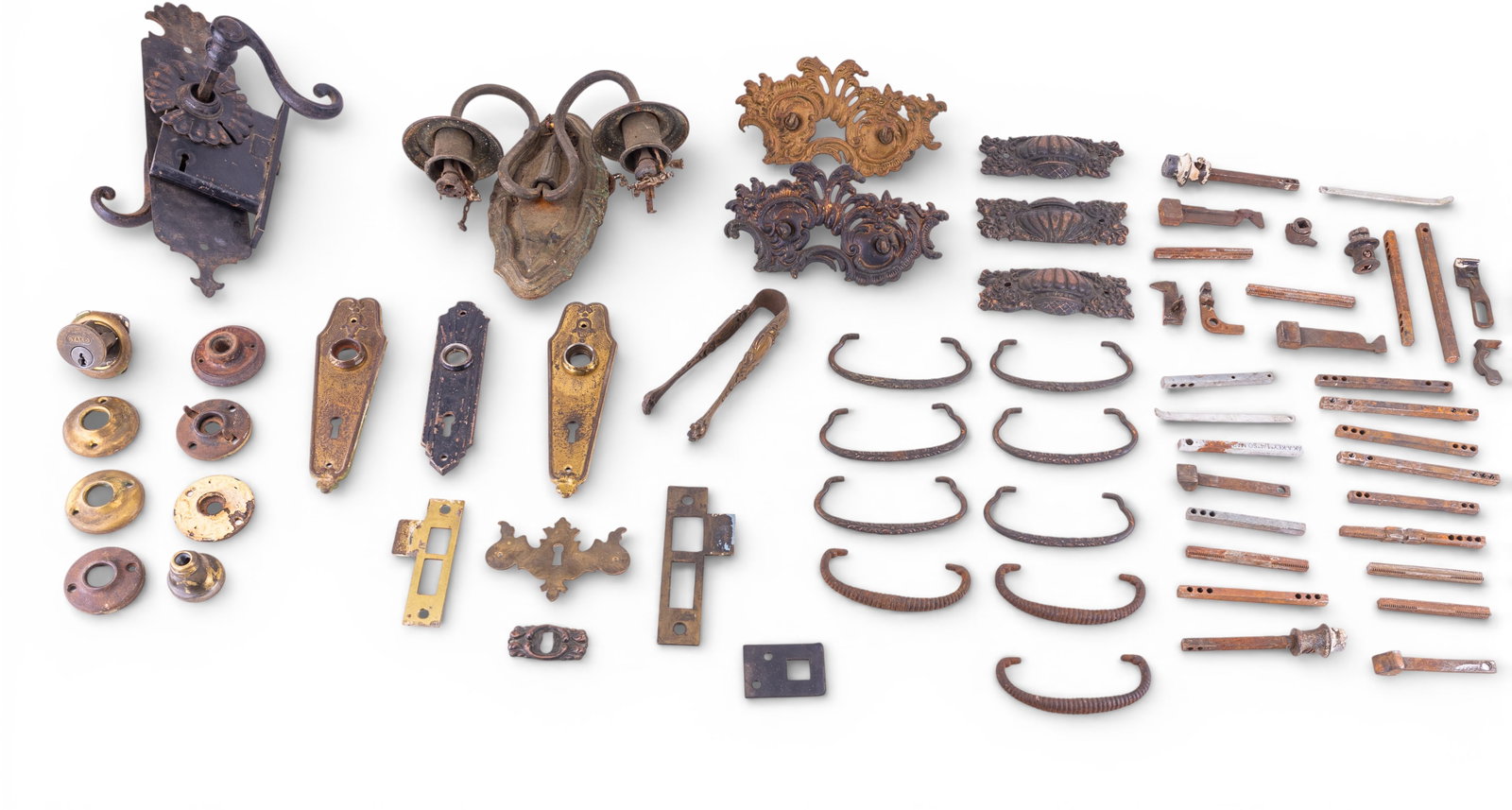 Antique Brass & Iron Door Hardware: An assortment of ornate brass drawer pull back plates, Art Deco back plate escutcheons, various doorknob posts, a cast metal electric candle wall sconce, and an iron door handle with lock and back