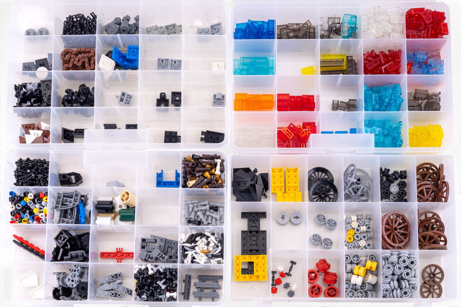LEGO Parts and Wheels in Organized Cases: LEGO pieces sorted into plastic cases with multiple compartments. Includes translucent parts, wheels, axles, blocks, specialty pieces, and connectors in a variety of shapes and colors. Suitable for us