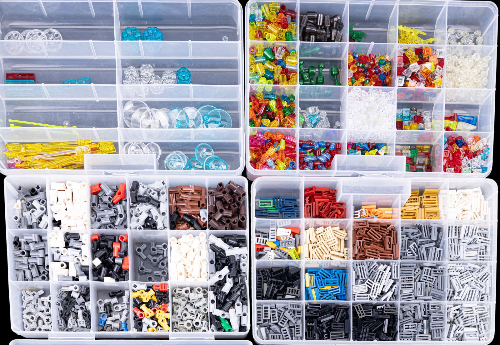 Four Containers of Assorted LEGO Bricks: Four clear plastic containers filled with assorted LEGO pieces. Includes technic axle connectors, tile 1?2 grille louvers, small translucent parts, and other categorized components. Each container has
