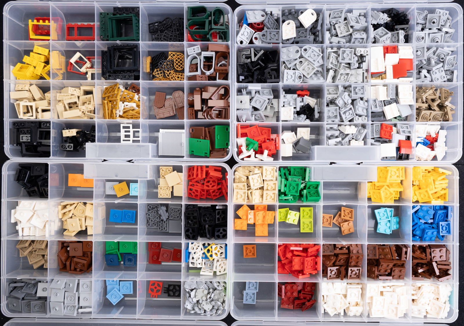 Sorted LEGO Parts in Organizers: LEGO parts stored in plastic organizers with labeled compartments. Includes 'Plate 2?2,' 'Plate 2?2 Modified,' 'Tile 2?2 1 Jumper Stud Turntable Flat Bottom,' and 'Windows.' Each compartment contains