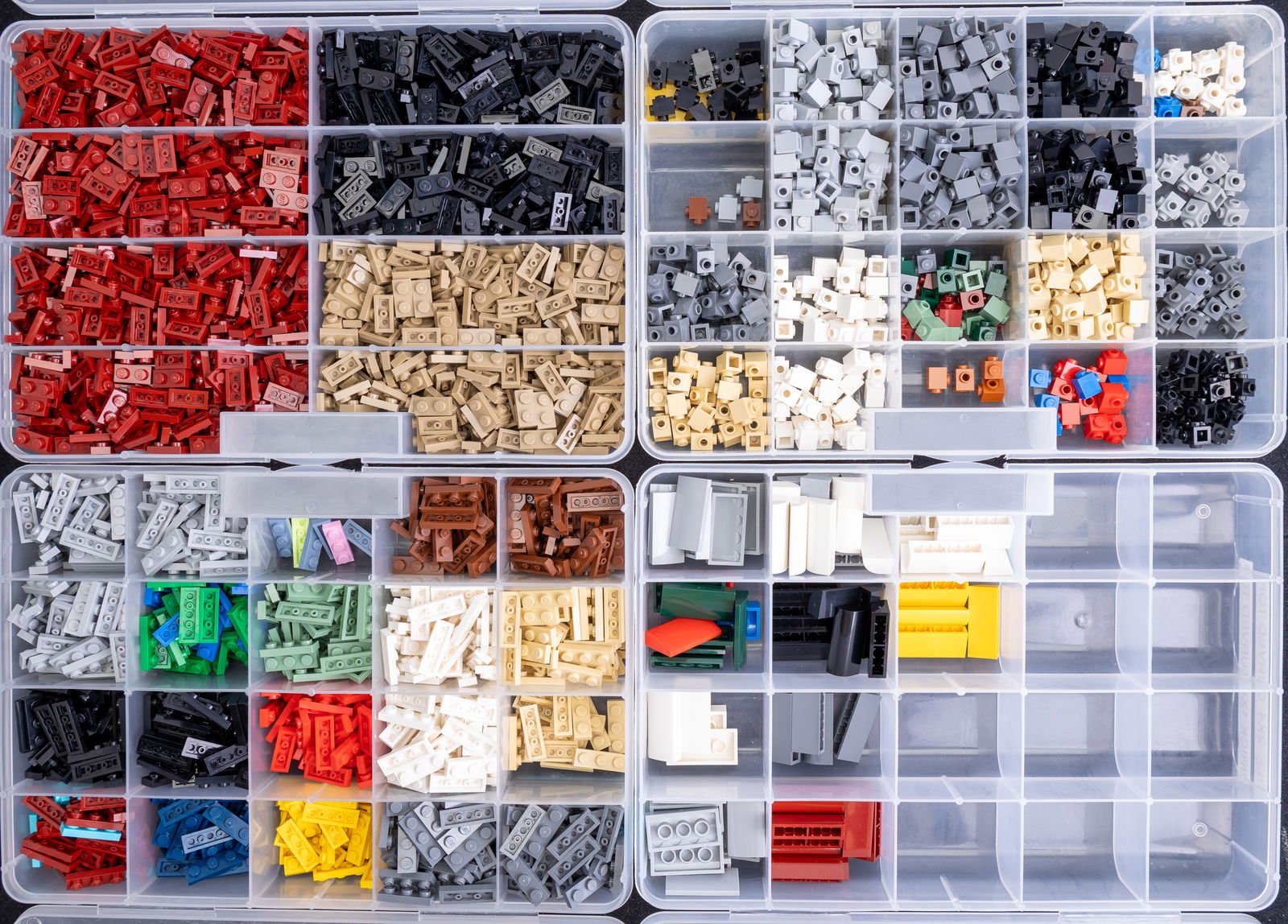 LEGO Parts in Stackable Storage Boxes: LEGO parts organized in stackable plastic storage boxes. Includes labeled compartments containing various piece types such as Plate 1?3, Plate 1?2 Dark Red, Tile 2?4 Curved Top, Brick 1?4 Curved Top,