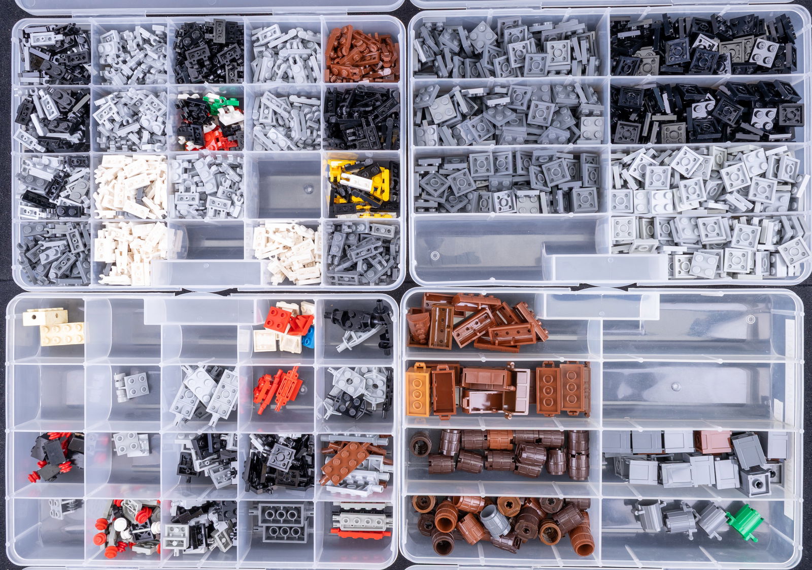 LEGO Parts Organization Boxes: Plastic organization boxes labeled and filled with various LEGO parts. Boxes include sections for 'Plate 2?2,' 'Plate 1?2 Modified,' 'Wheel Mounts/Axles,' and 'Small Barrels/Crates/Chests.' Each box c