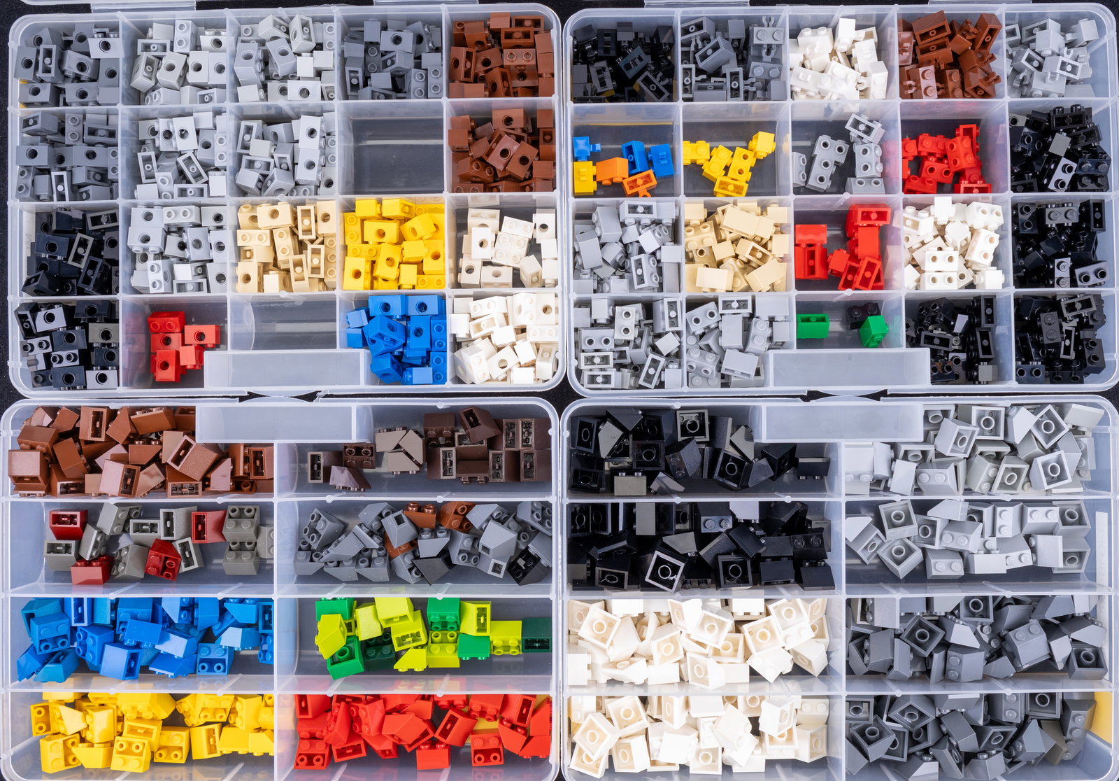 LEGO Bricks in Sorting Containers: LEGO bricks stored in labeled, compartmentalized plastic containers. Includes categories such as 'BRICK 2x2 SLOPE,' 'BRICK 1x2 MODIFIED, ONE PIN HOLE,' and more. Includes various colors like red, blue