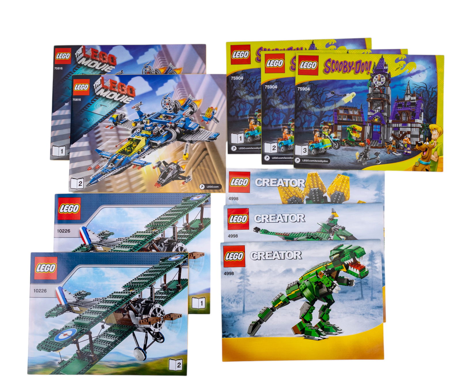 LEGO Instruction Booklets and Sticker Sheets: LEGO instruction booklets and sticker sheets for various sets, including models such as 10226 Sop with Camel, Creator dragon-themed set (4994), Scooby-Doo-themed set (75904), and The LEGO Movie set