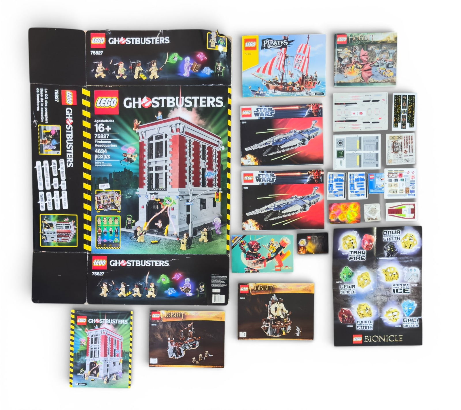 LEGO Instruction Booklets, Stickers, and Box: LEGO instruction booklets, stickers, and an empty, flattened box. Includes manuals for sets such as "The Hobbit," "Pirates," "Star Wars," "Ghostbusters," and more, along with corresponding sticker she