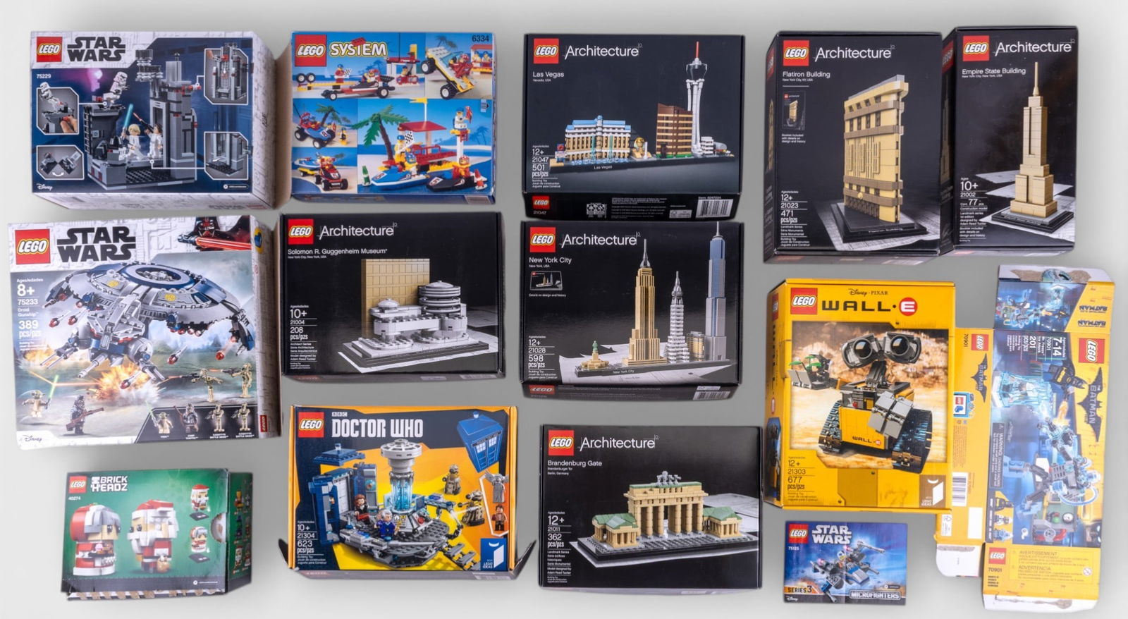 Flattened Empty LEGO Boxes: A selection of flattened and empty LEGO boxes from various themes, such as Star Wars, Architecture, City, and Batman. Some boxes may contain instruction booklets. No LEGO pieces are included. Ideal