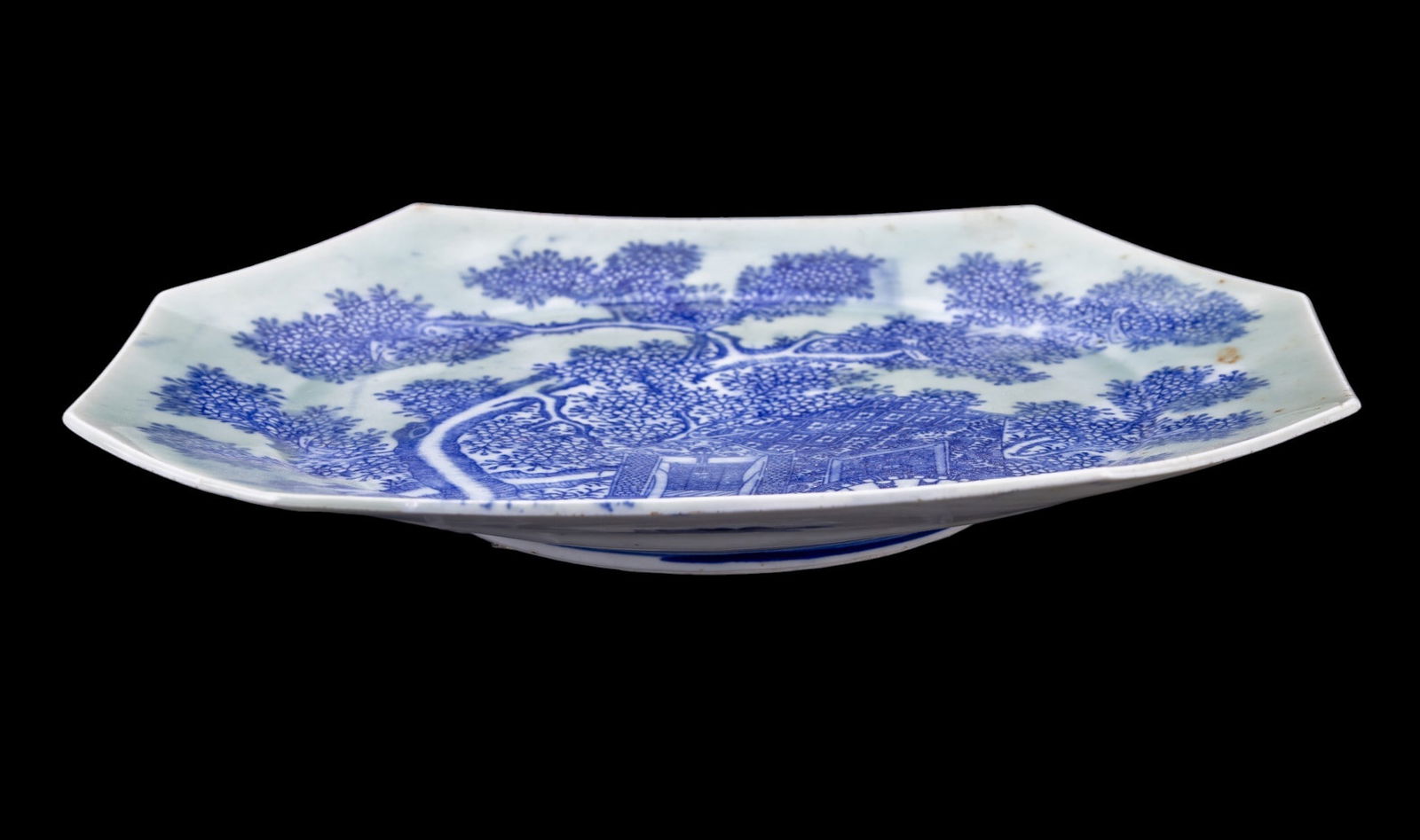 Japanese Seiji Transferware with Celadon Glaze: A Japanese Seiji period porcelain platter featuring blue and white transfer painted rickshaw and tree scene with a celadon over-glaze. Measures approx. 13" W x 10" H.