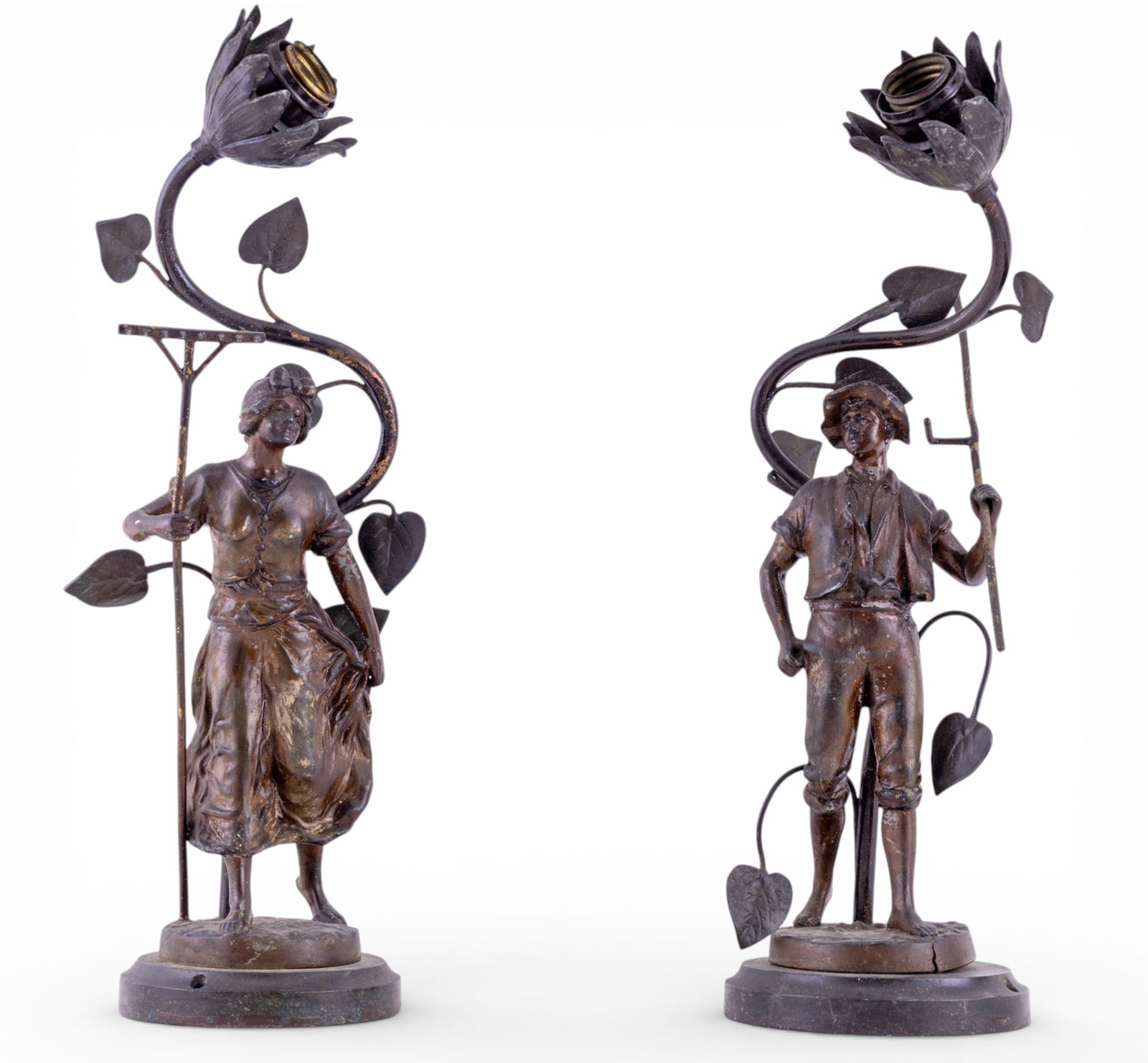 Antique Spelter Figural Lamp Pair: A pair of antique spelter figural table lamps depicting a man and woman farmer couple with figural flower light sockets over their heads. Untested, will require rewiring, both measure approx. 15" H.