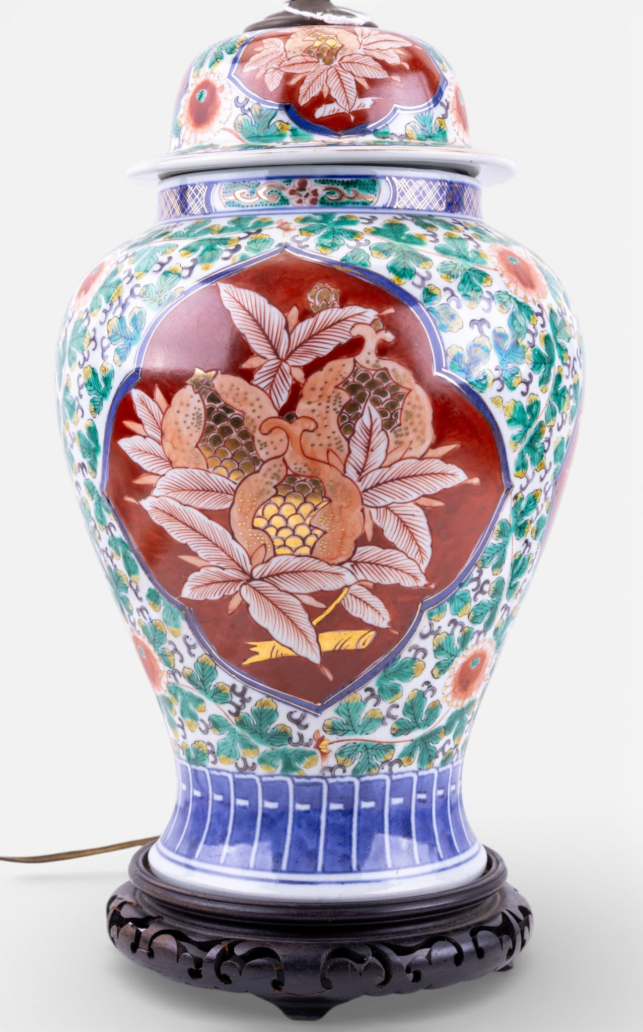 Vintage Imari Ware Ginger Jar Lamp: A vintage Japanese porcelain Imari ware ginger jar lamp, featuring reticulated wooden base and two light sockets. Note some loss to feet of wooden base, untested, measures approx. 26" to the socket,