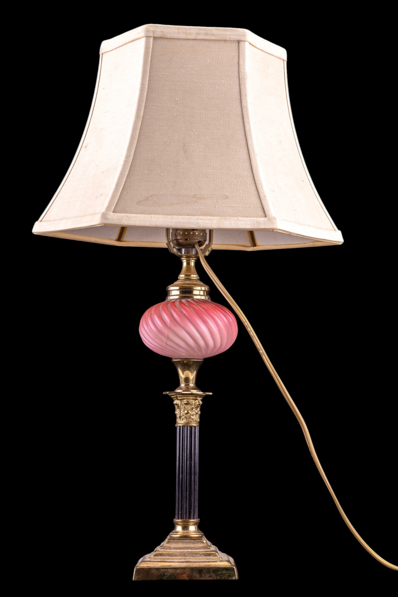 Vintage Cranberry Satin Glass Body Lamp: A vintage Victorian style table lamp featuring Corinthian column brass details and a cranberry satin glass swirl belly, untested, measures approx. 20" to the finial.