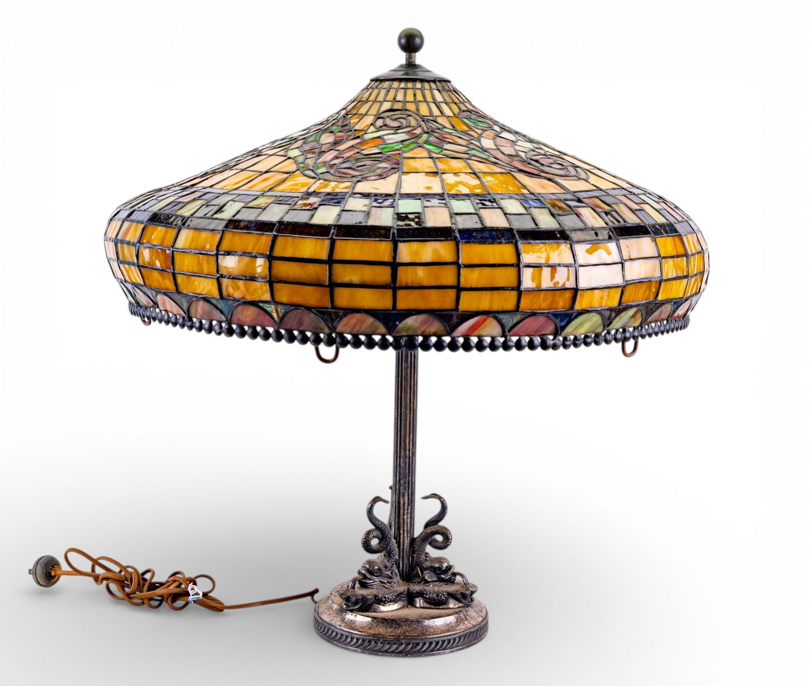 Antique Lamp w/ Antique Style Slag Glass Shade: An antique silver plated table lamp with an antique style slag glass shade measuring approx. 24" high x 20.5" diameter. Lamp has figural fish surrounding base. Some wear to lamp as seen in