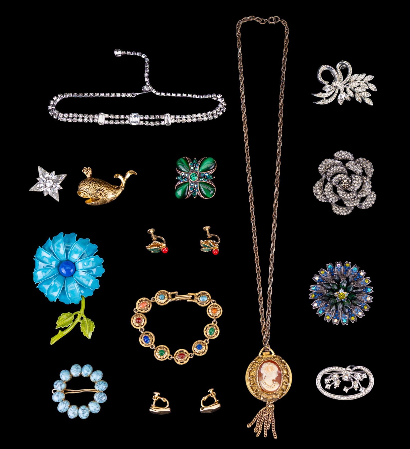 Vintage Costume Brooches and More: A collection of vintage costume jewelry including brooches by Monet and Weiss, a mid century enameled flower brooch, a faux cameo watch necklace, gold tone Napier screw back earrings, and more.