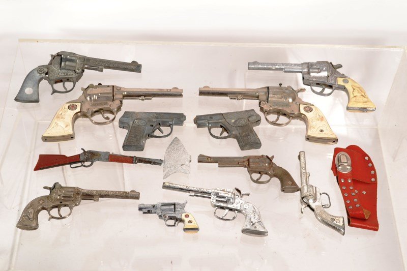 Lot of Vintage Pistol Toys: Cap guns, Western revolvers, Dick Tracy cap guns, Kilgore Pal pistol, Star pistol, a toy holster; all in varying degrees of condition